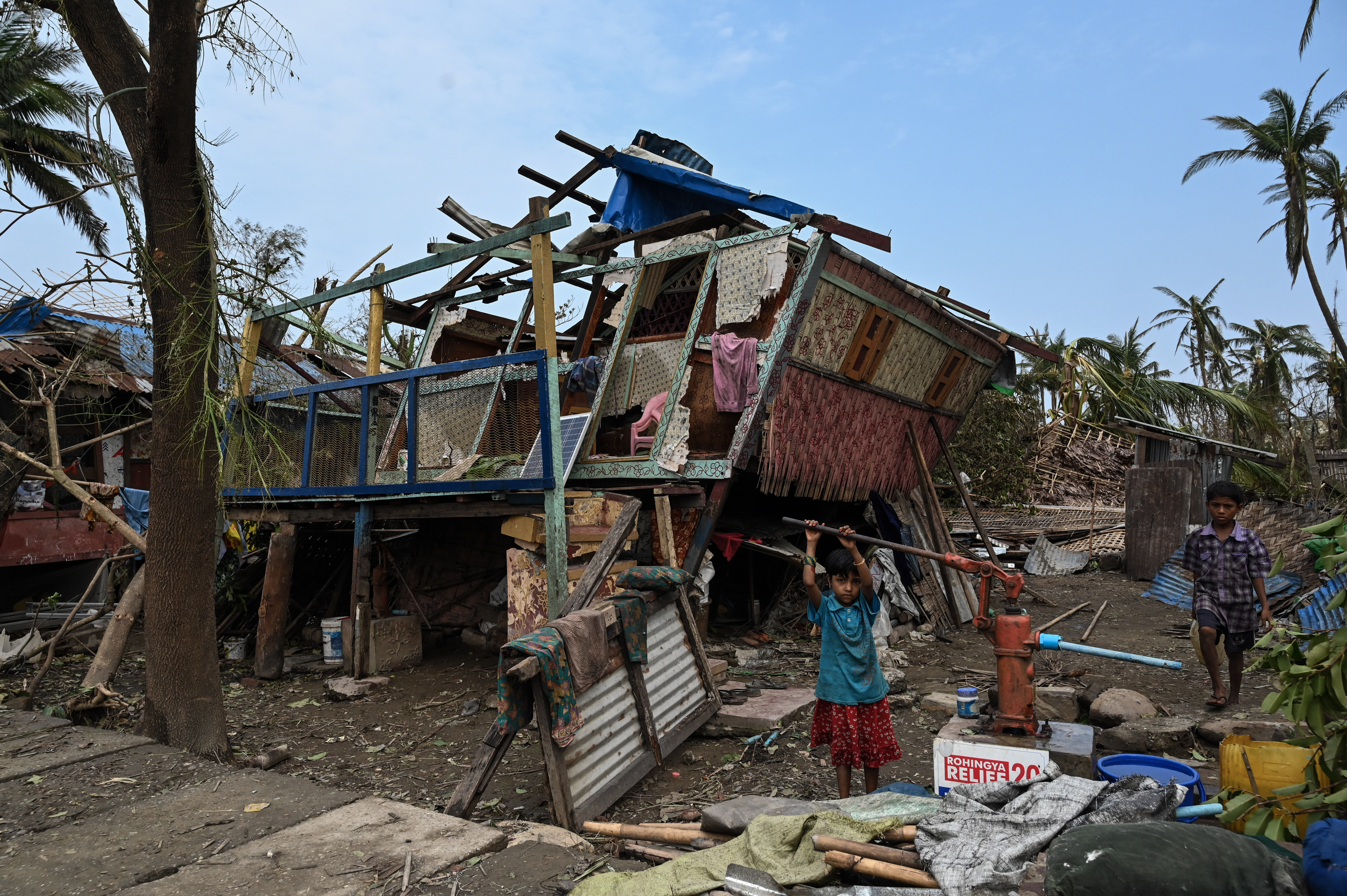 A girl draws water from a pump at Basara refugee camp in Sittwe