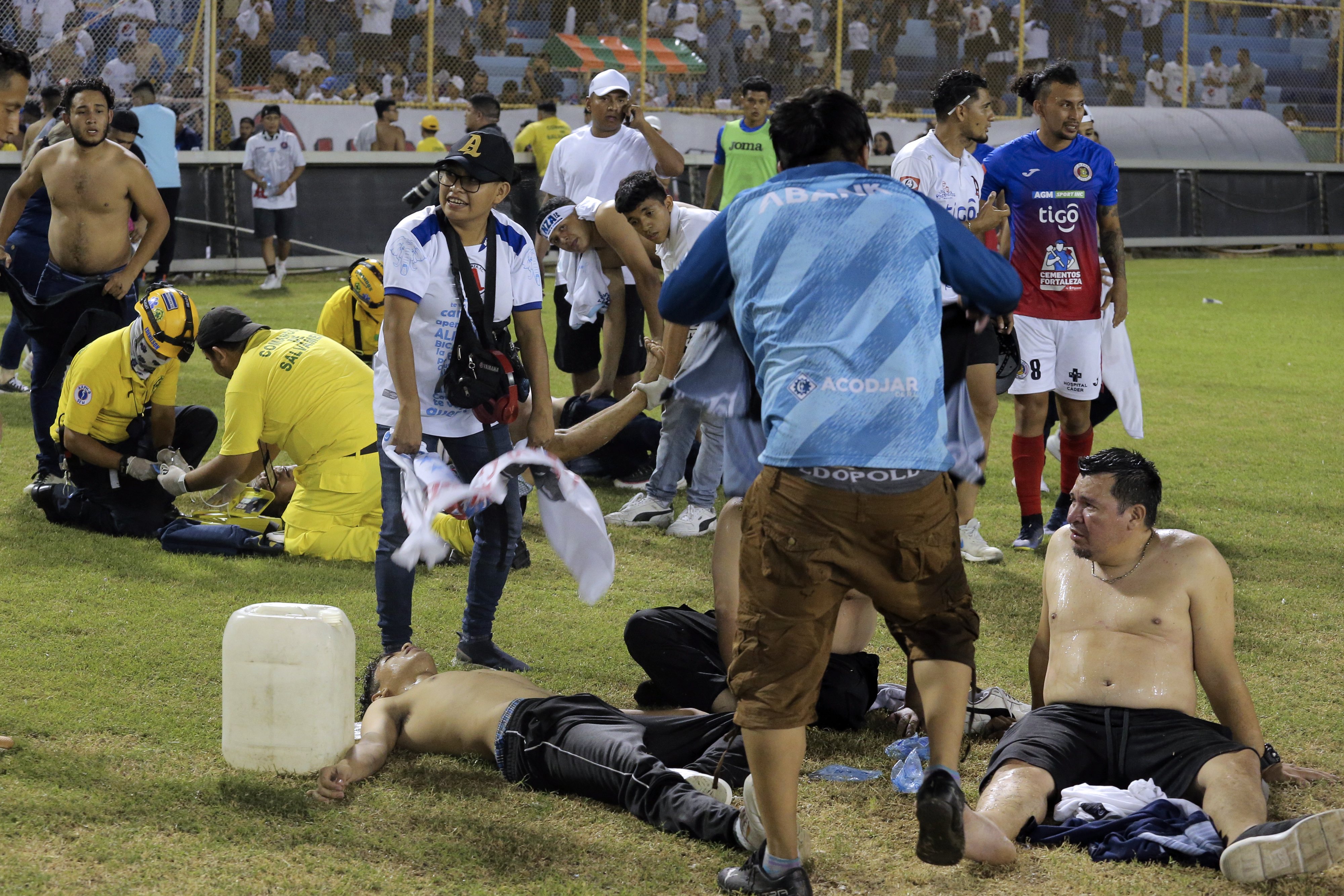 Supporters are helped by others following a stampede during a football match between Alianza and CD FAS at Cuscatlan stadium in San Salvador