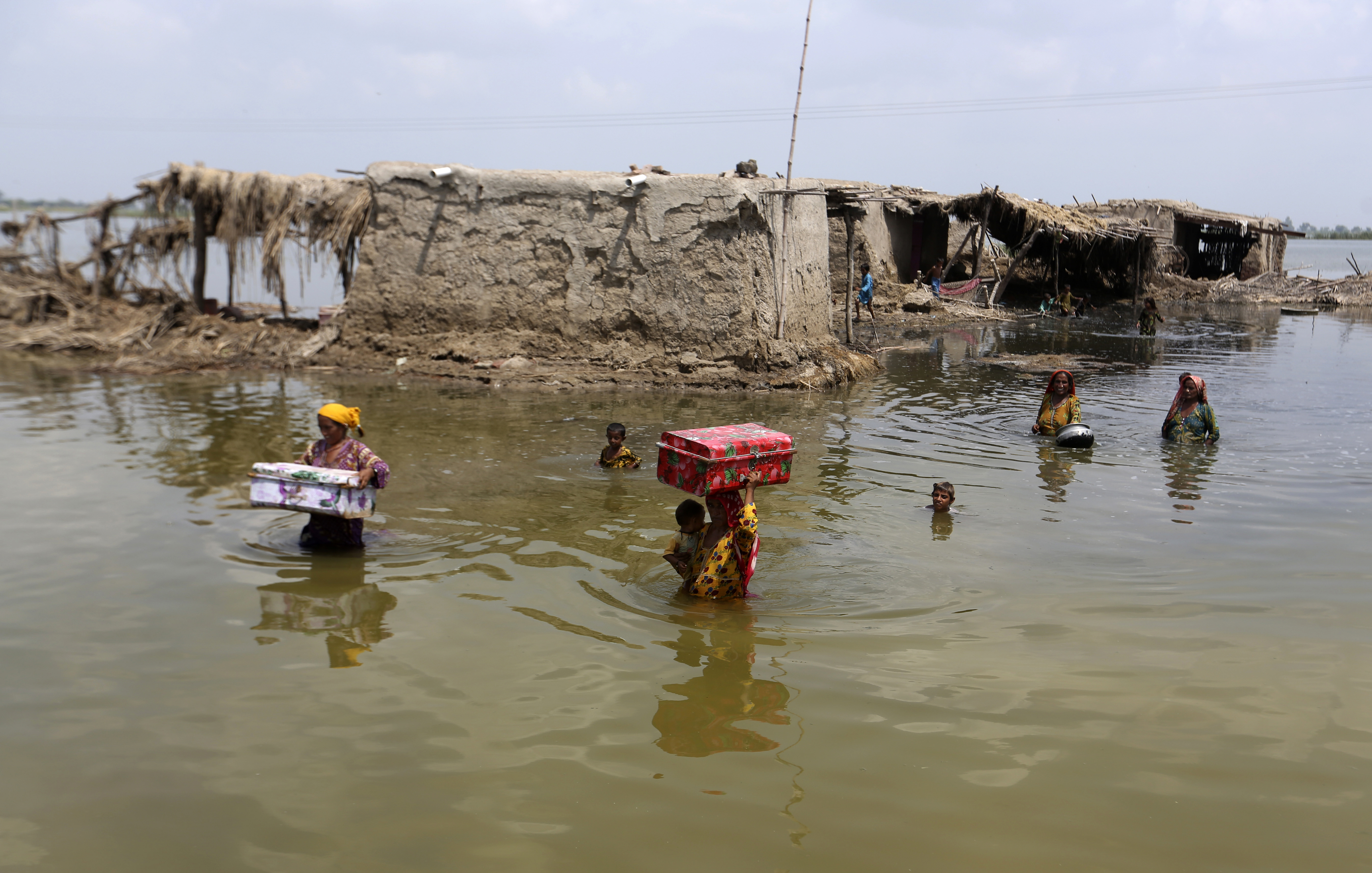 A photo of women carrying their belongings through floodwaters.