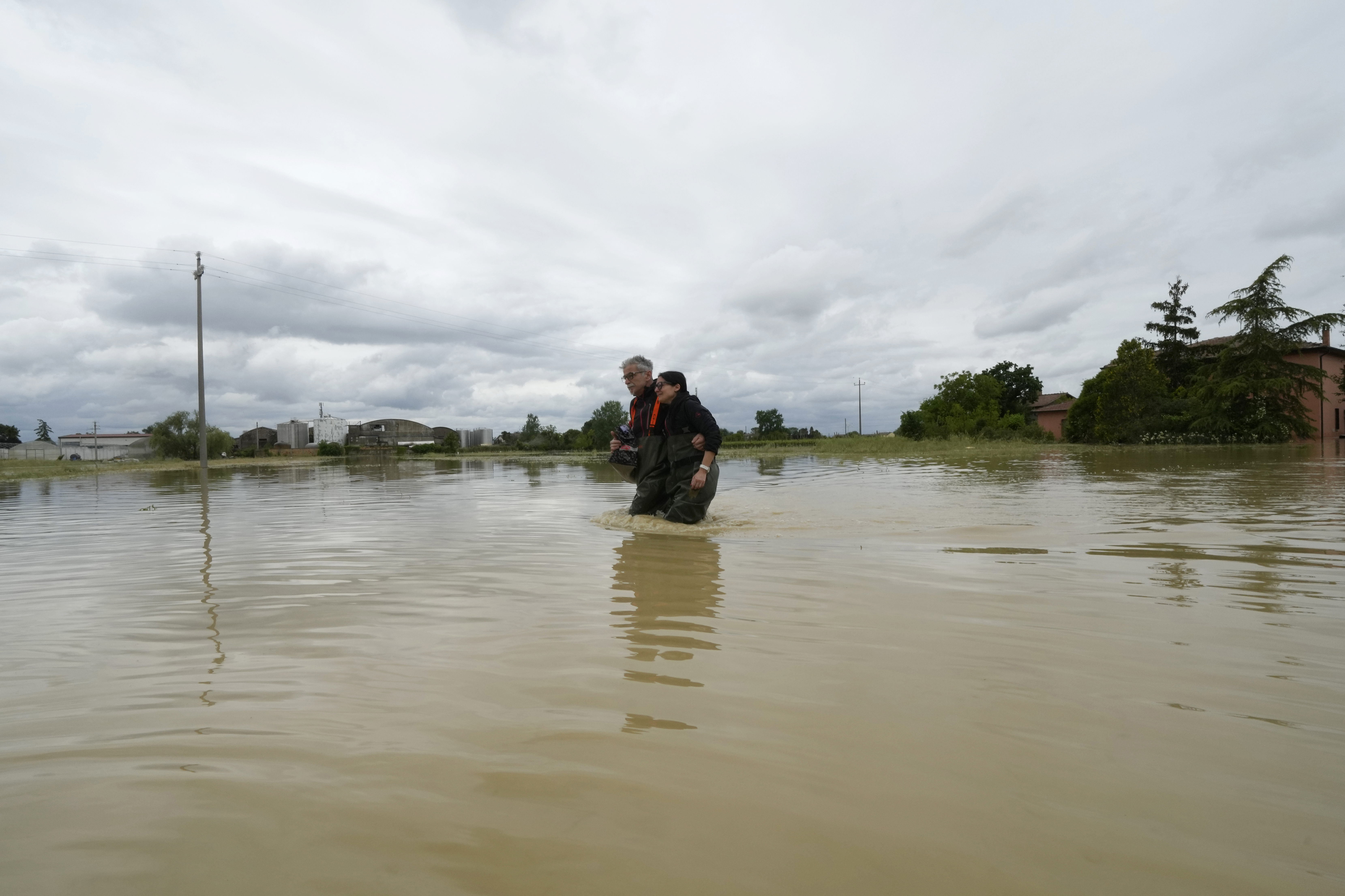 A couple stuck in the middle of the flooded road of Lugo, Italy, Thursday, May 18, 2023 [Luca Bruno/AP]