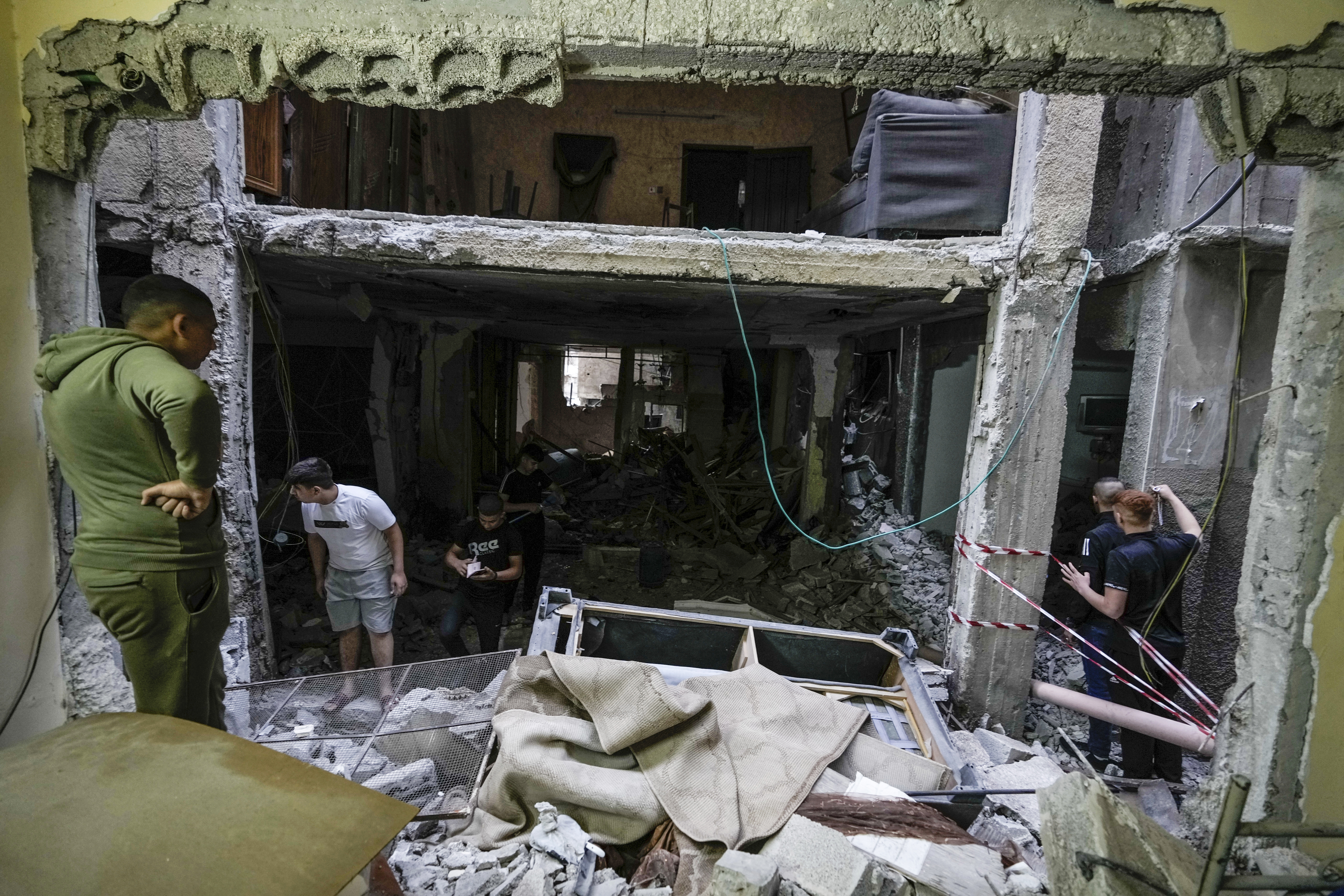 Palestinians inspect a damaged building following an Israeli army raid in the Balata refugee camp near the West Bank town of Nablus