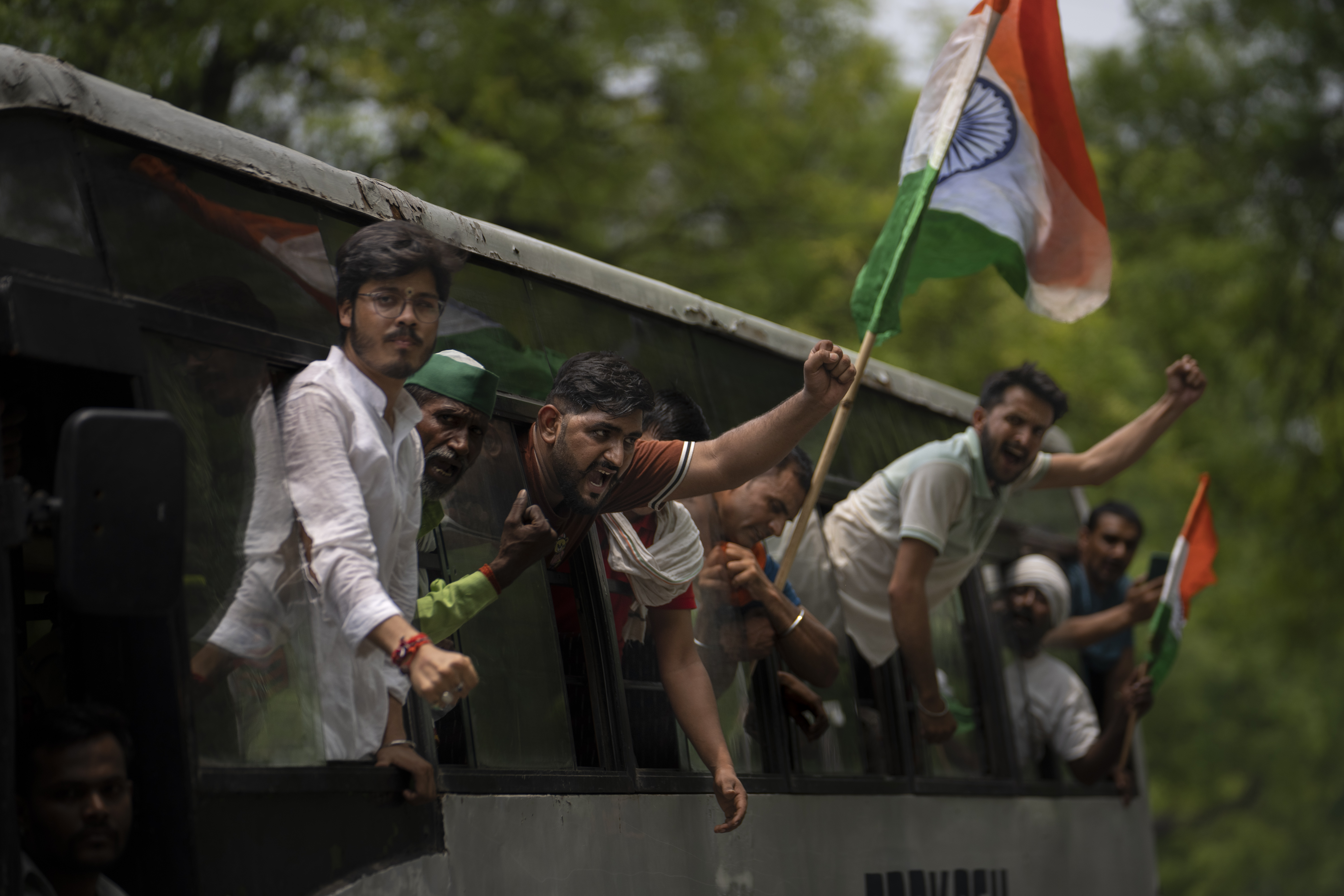 Supporters of India's top female wrestlers shout slogans from a bus after they were detained