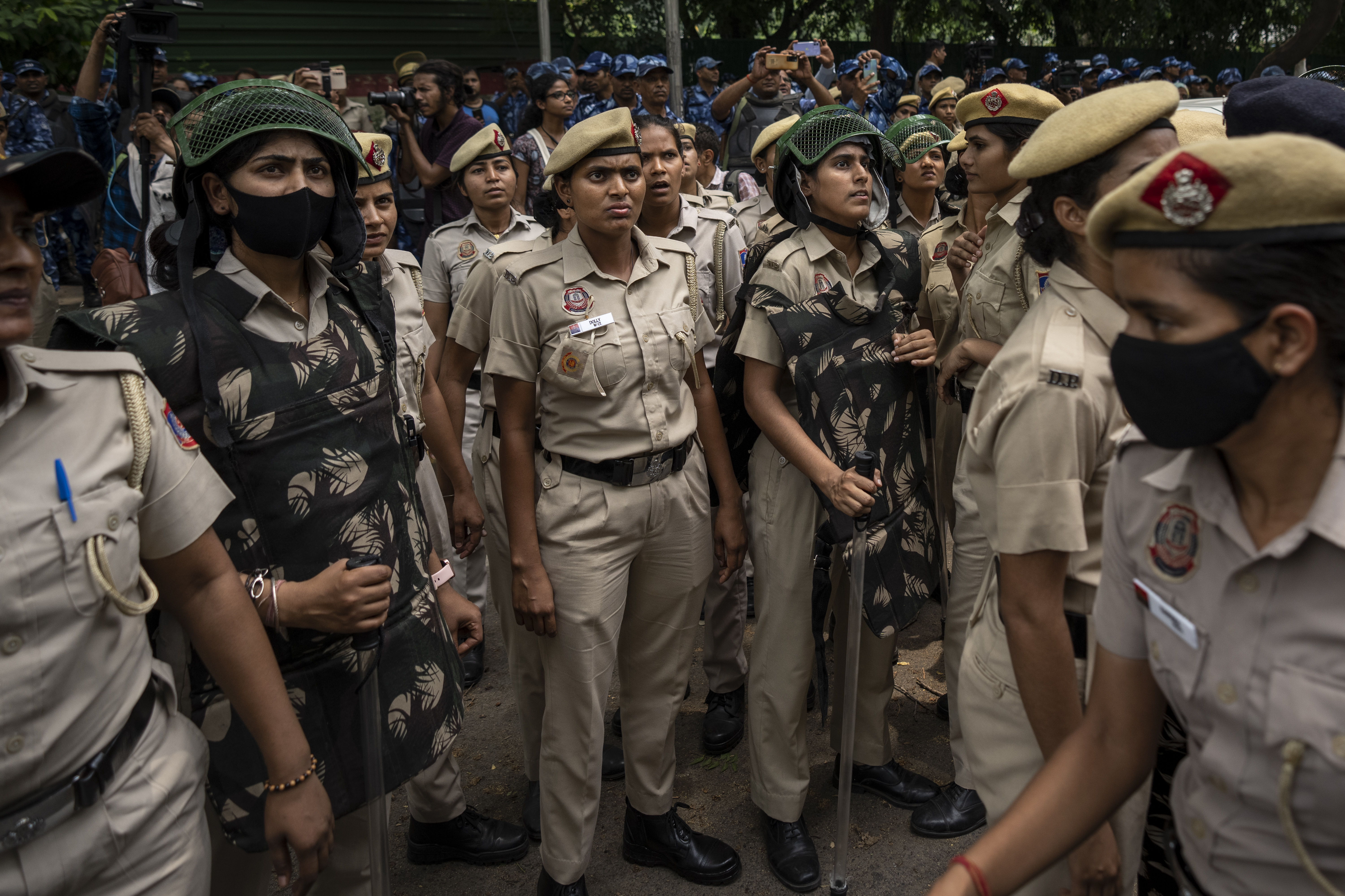 Police women watch as India's top female wrestlers are detained by the police