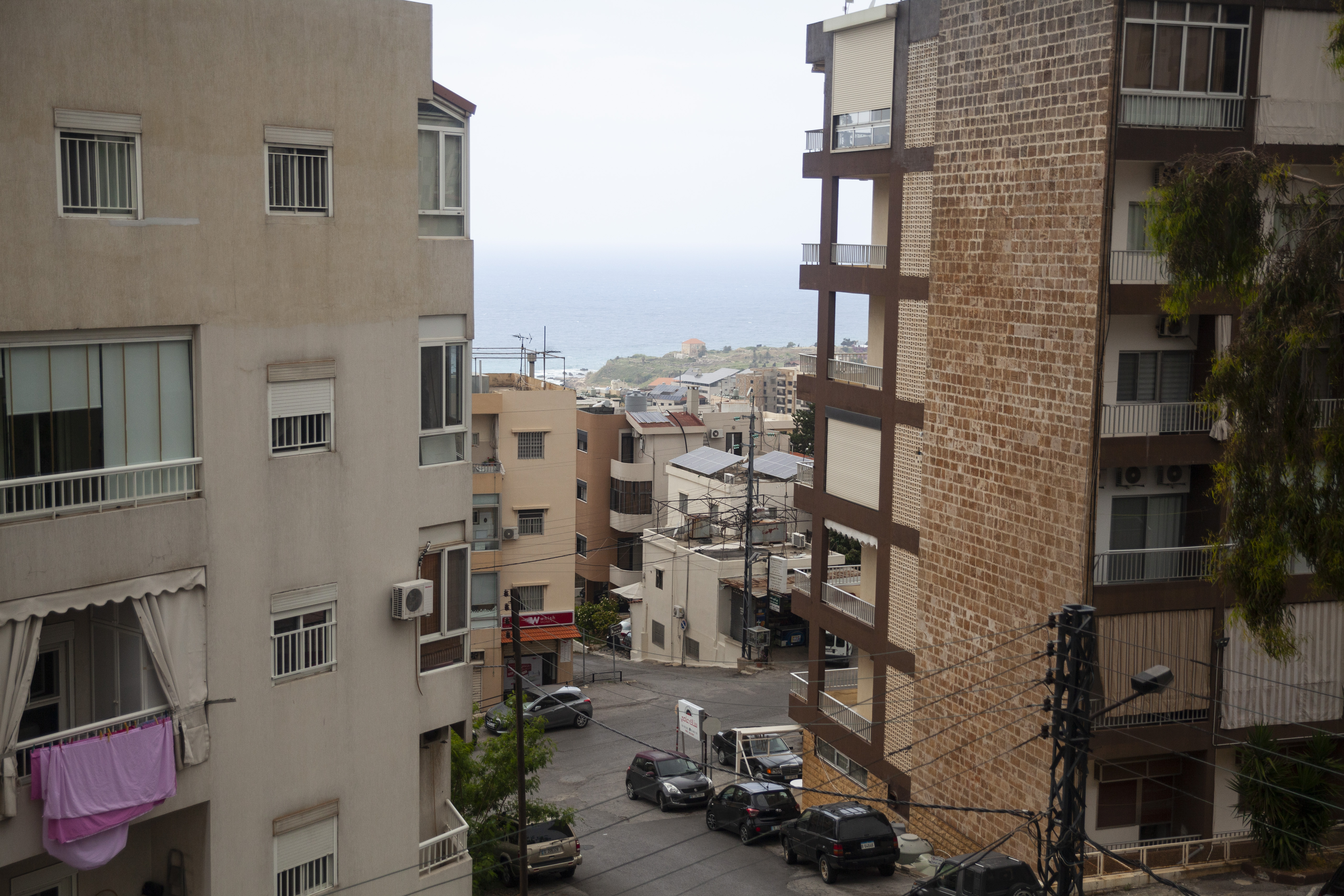 A photo of buildings and cars from a balcony view.