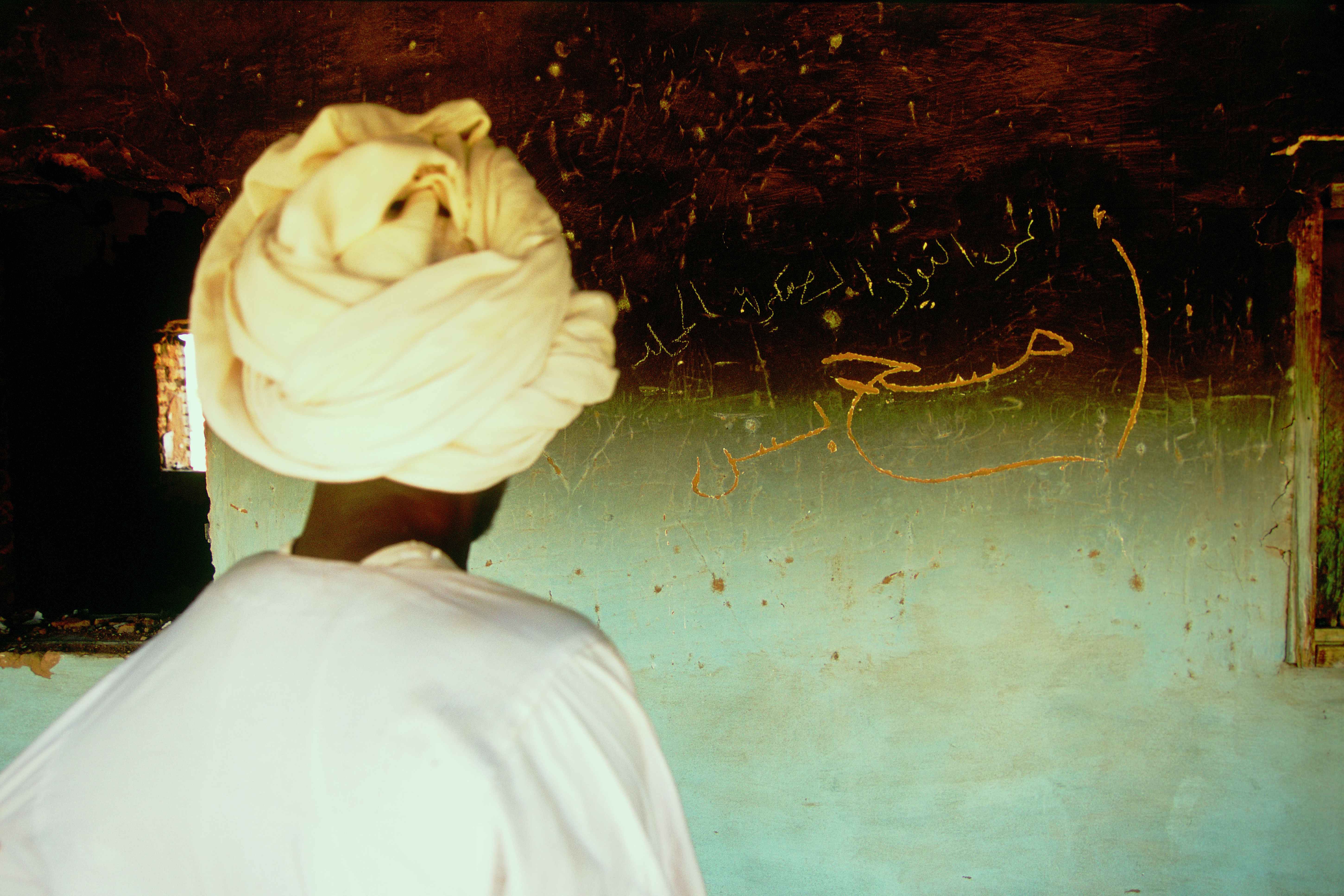An inscription on a wall in a burned house in Darfur in 2004