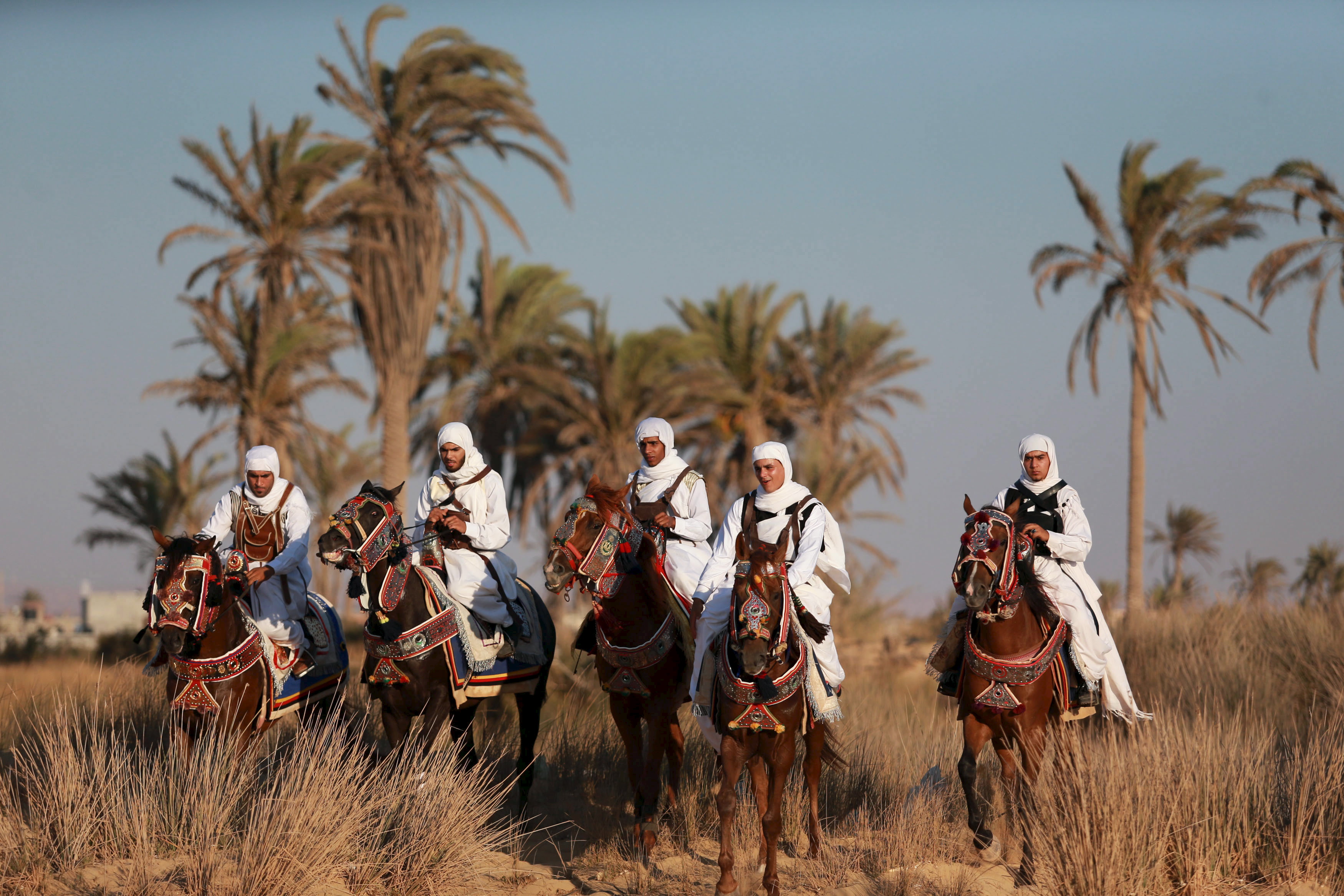 Horse riders, dressed in traditional costumes, mark Eid in Benghazi, Libya