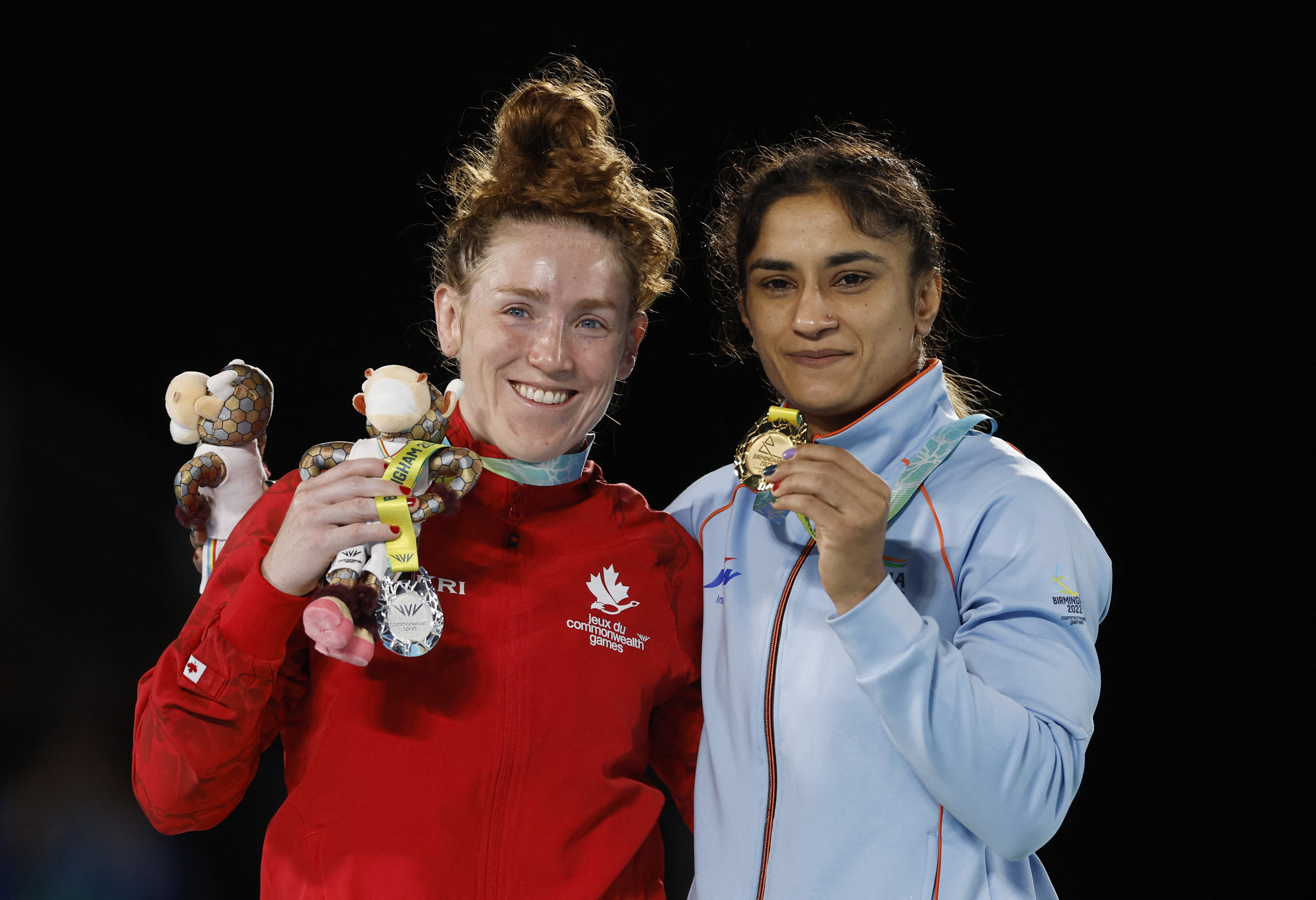 India's Vinesh Phogat celebrates with the gold medal alongside silver medalist Canada's Samantha Stewart