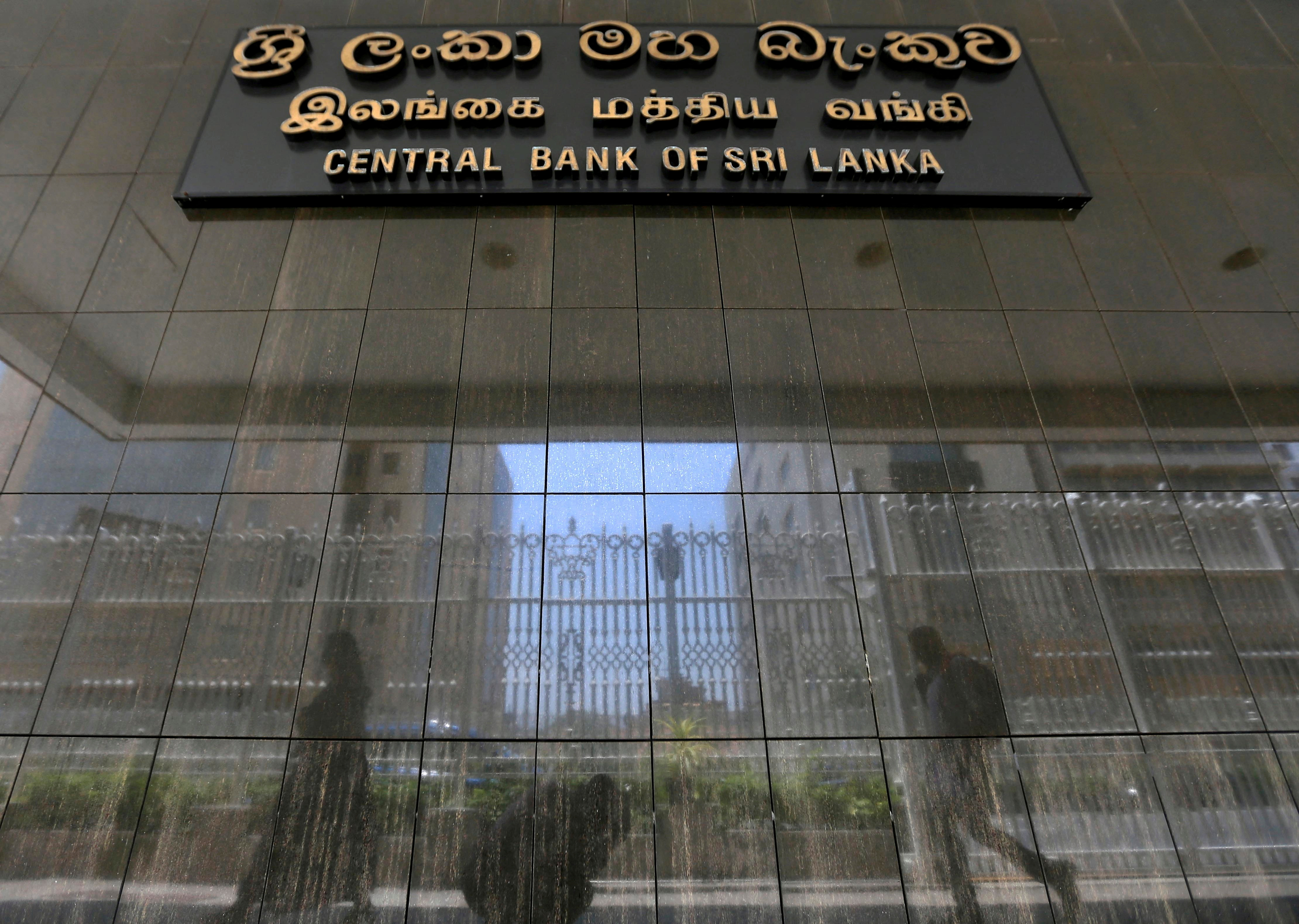 People walk past the main entrance of Sri Lanka's central bank in Colombo