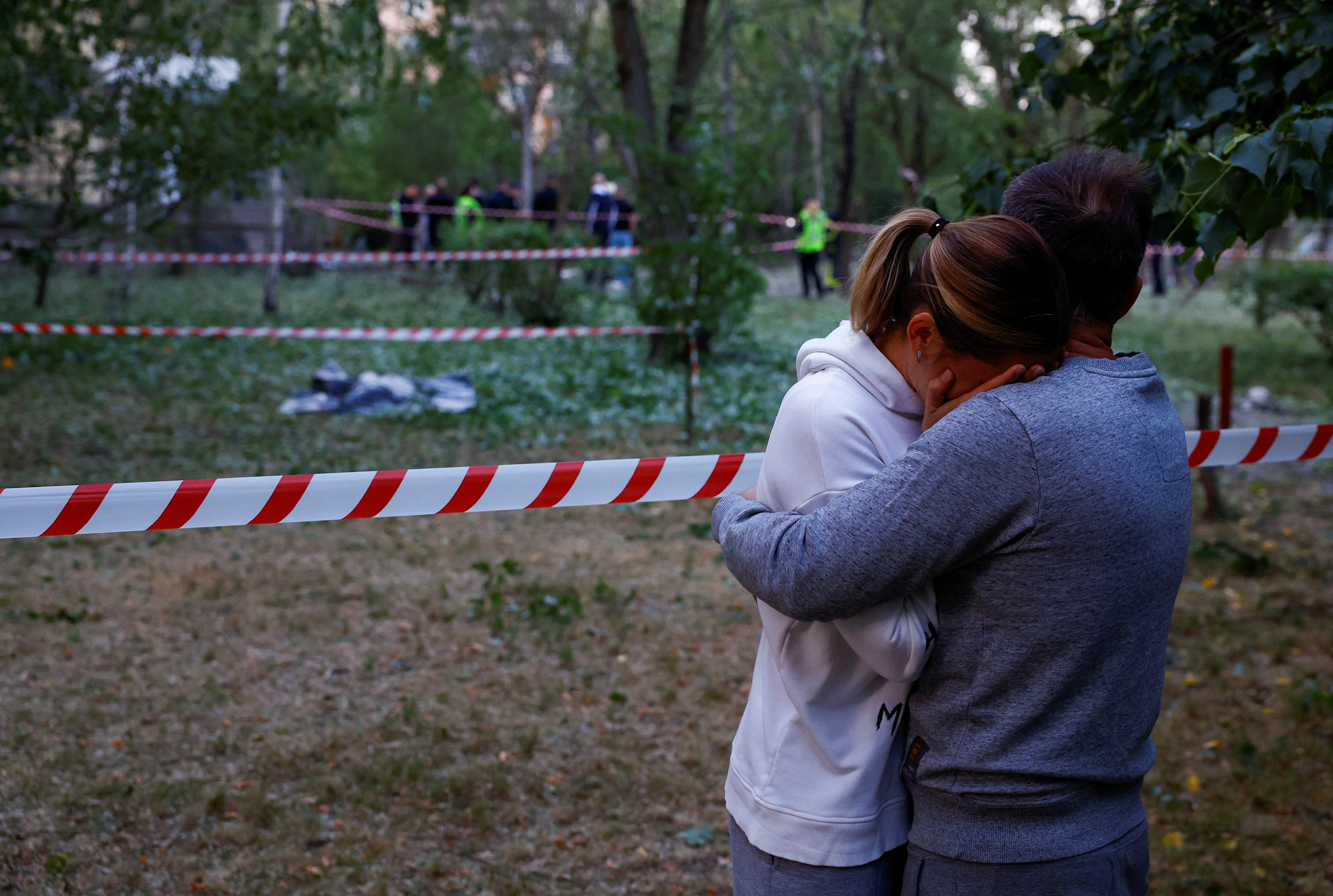 Local residents embrace near to where a person was killed - during a Russian missile attack - at a municipal medical clinic in Kyiv, Ukraine, on June 1, 2023