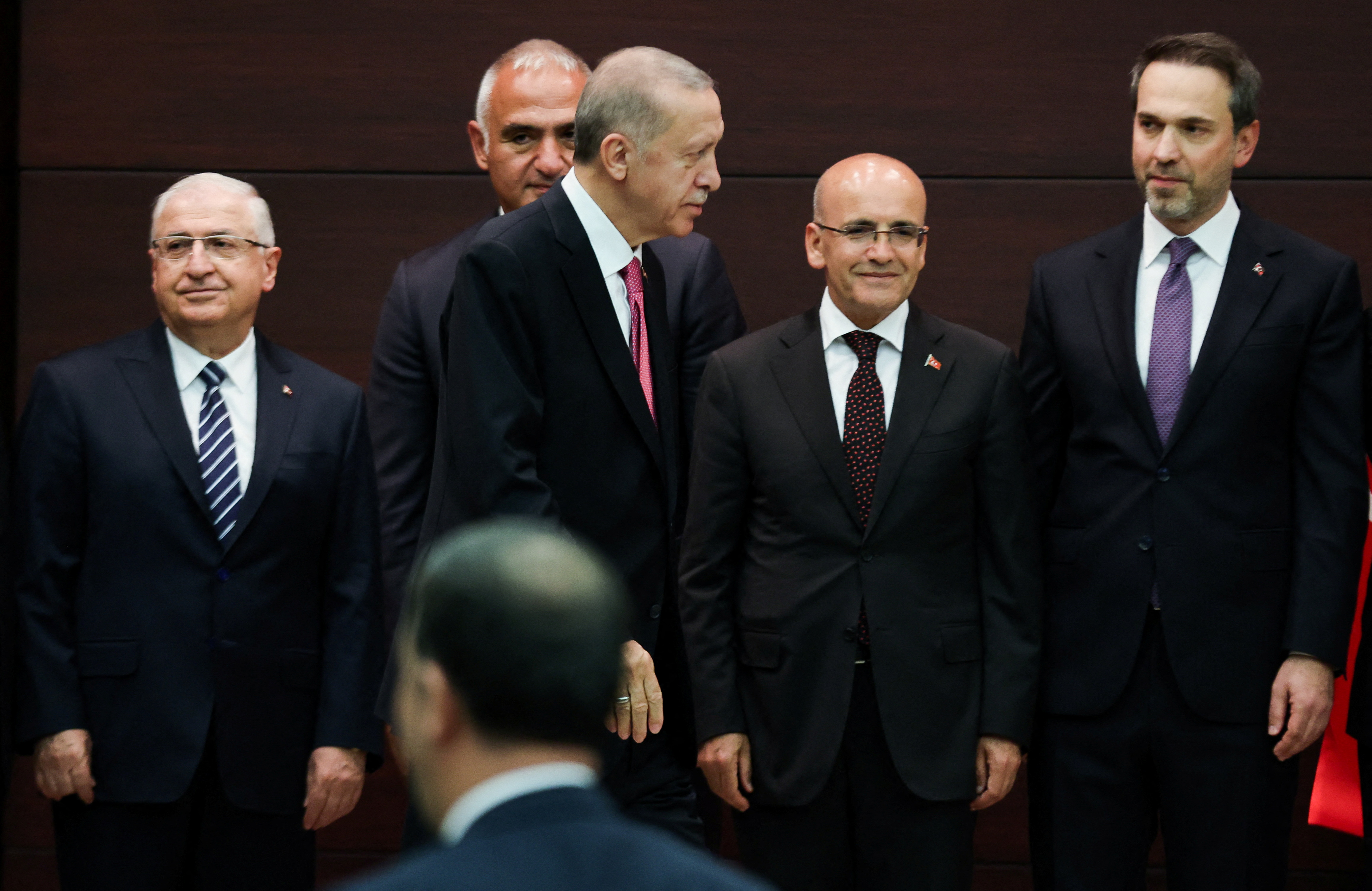 Turkish President Tayyip Erdogan walks next to the new Treasury and Finance Minister Mehmet Simsek during a press conference