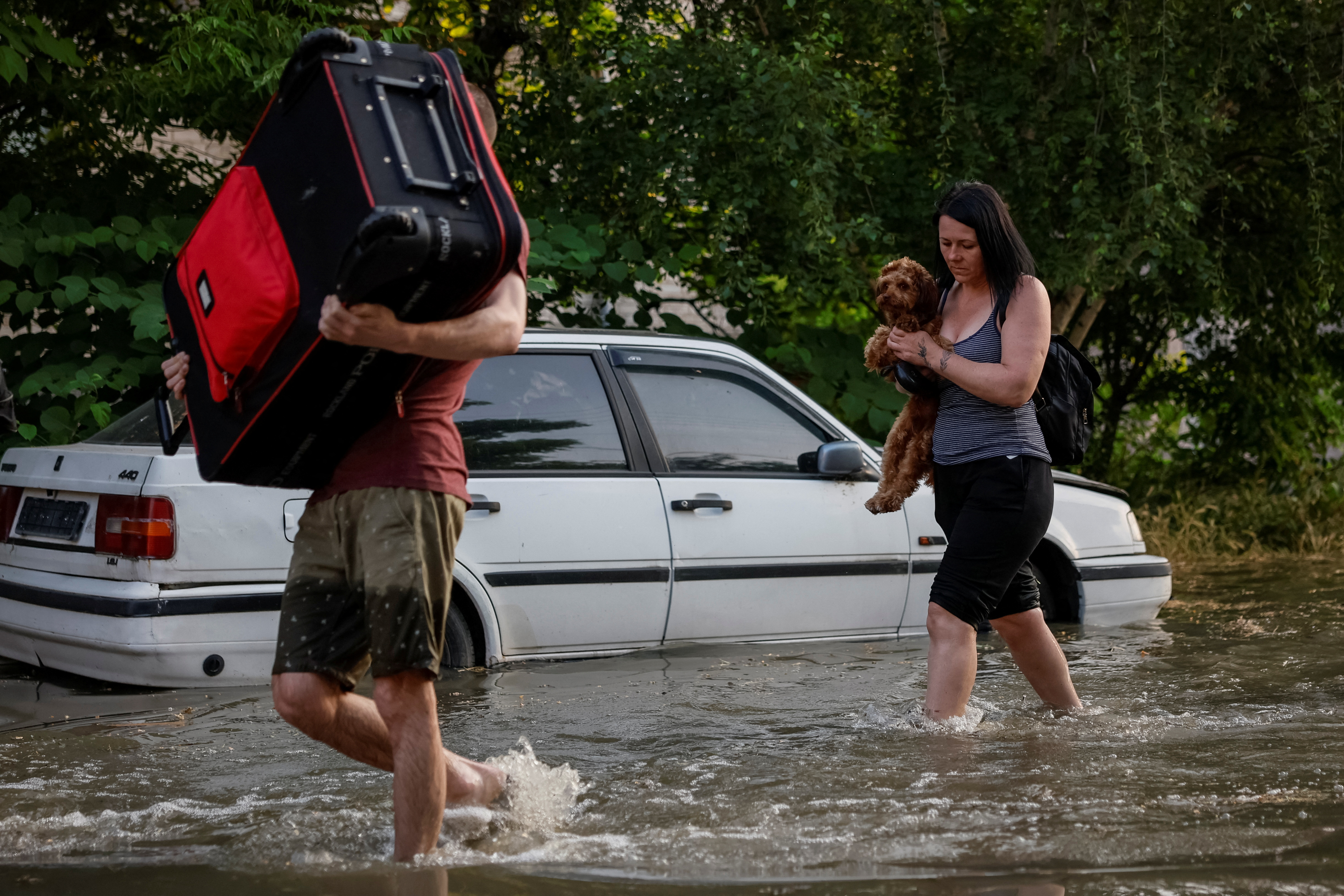 Residents carry their belongings in a flooded street after the Nova Kakhovka dam breached, Kherson, Ukraine