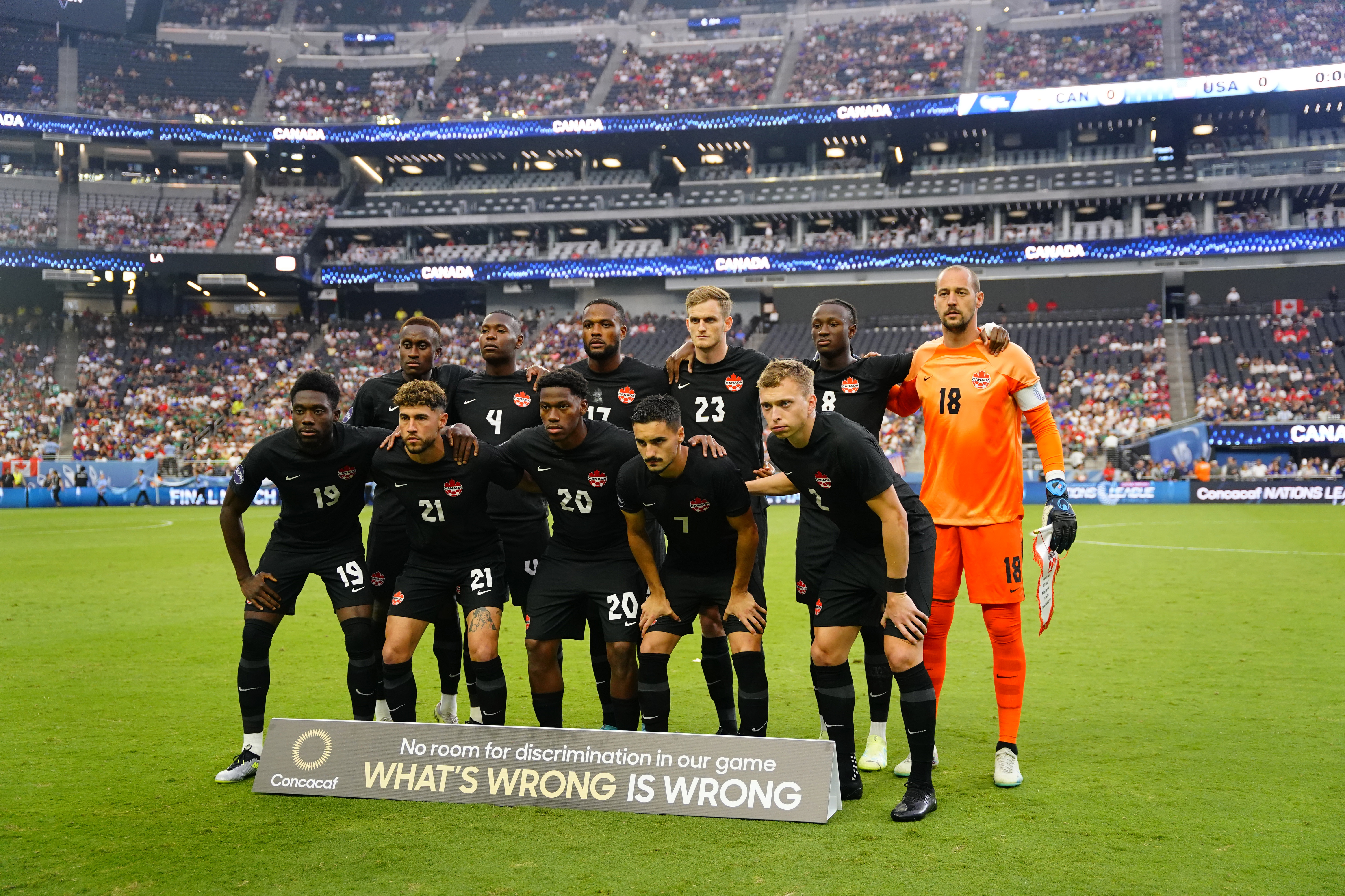 Canadian players, dressed in black, pose for team photo