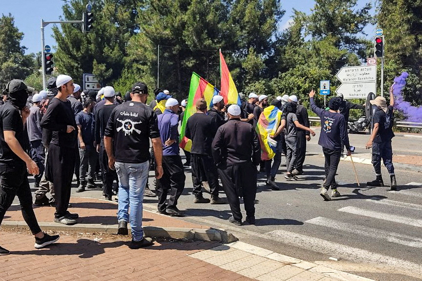 A person holds a flare as members of Israel's Druze minority protest plans to build a series of wind turbines