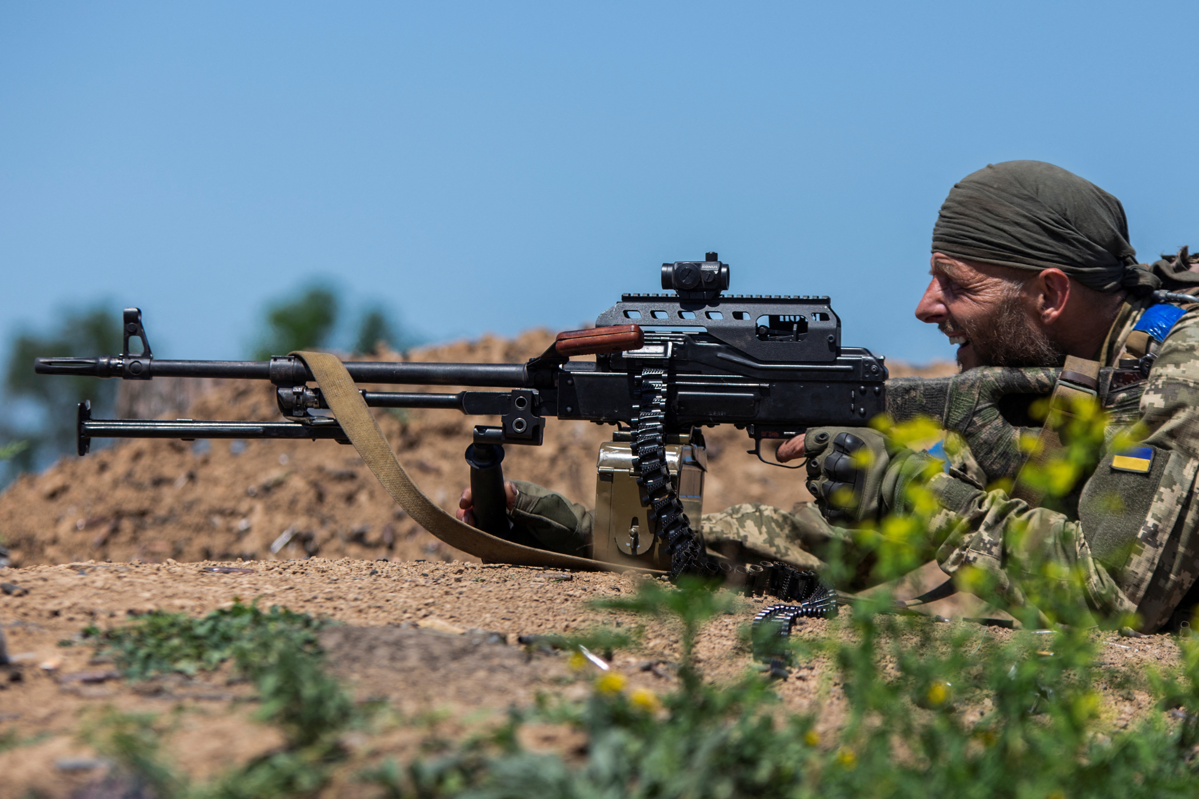 A soldier firing a machine gun