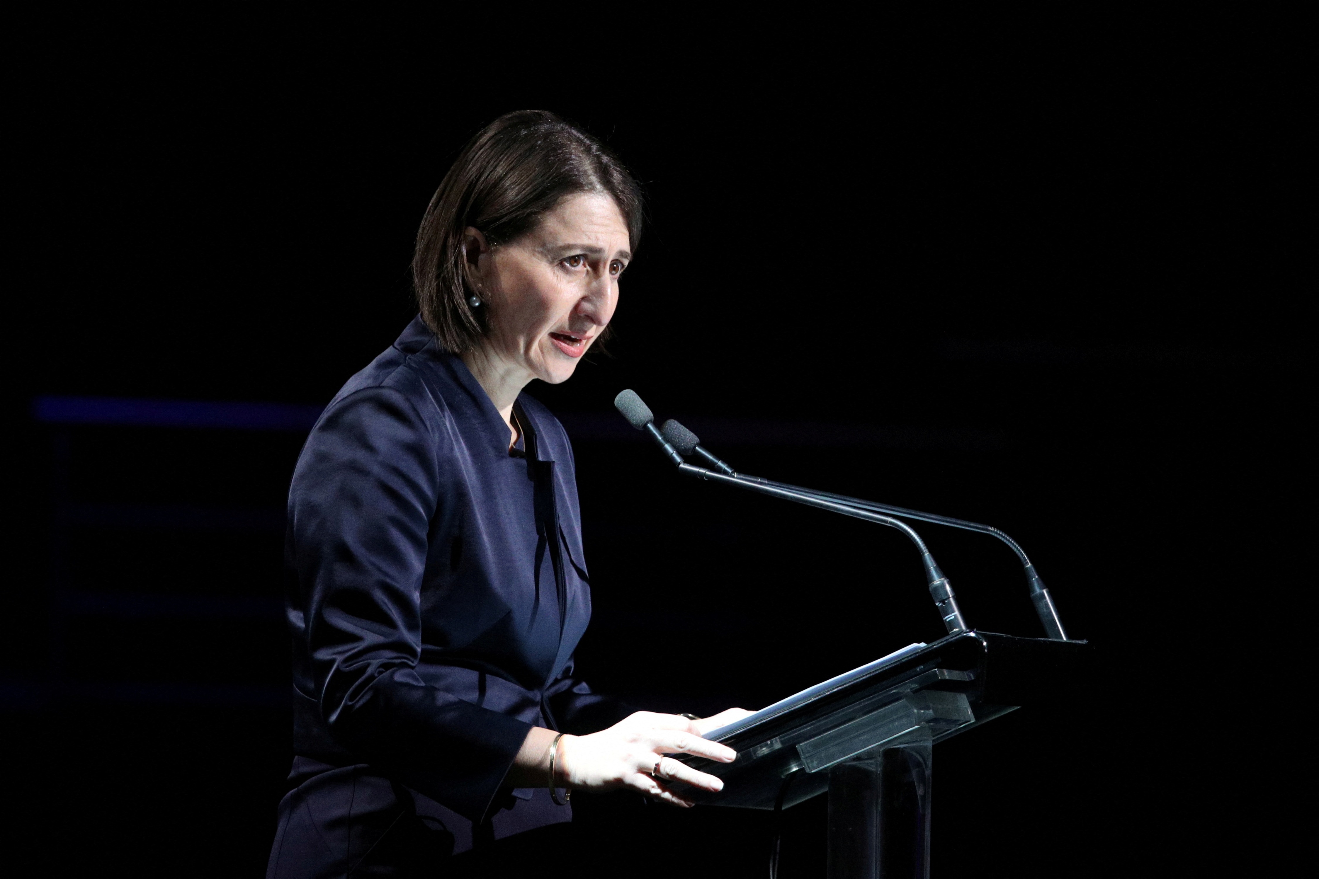 Gladys Berejiklian speaking when she was NSW premier. She is standing at a lectern with a microphone.