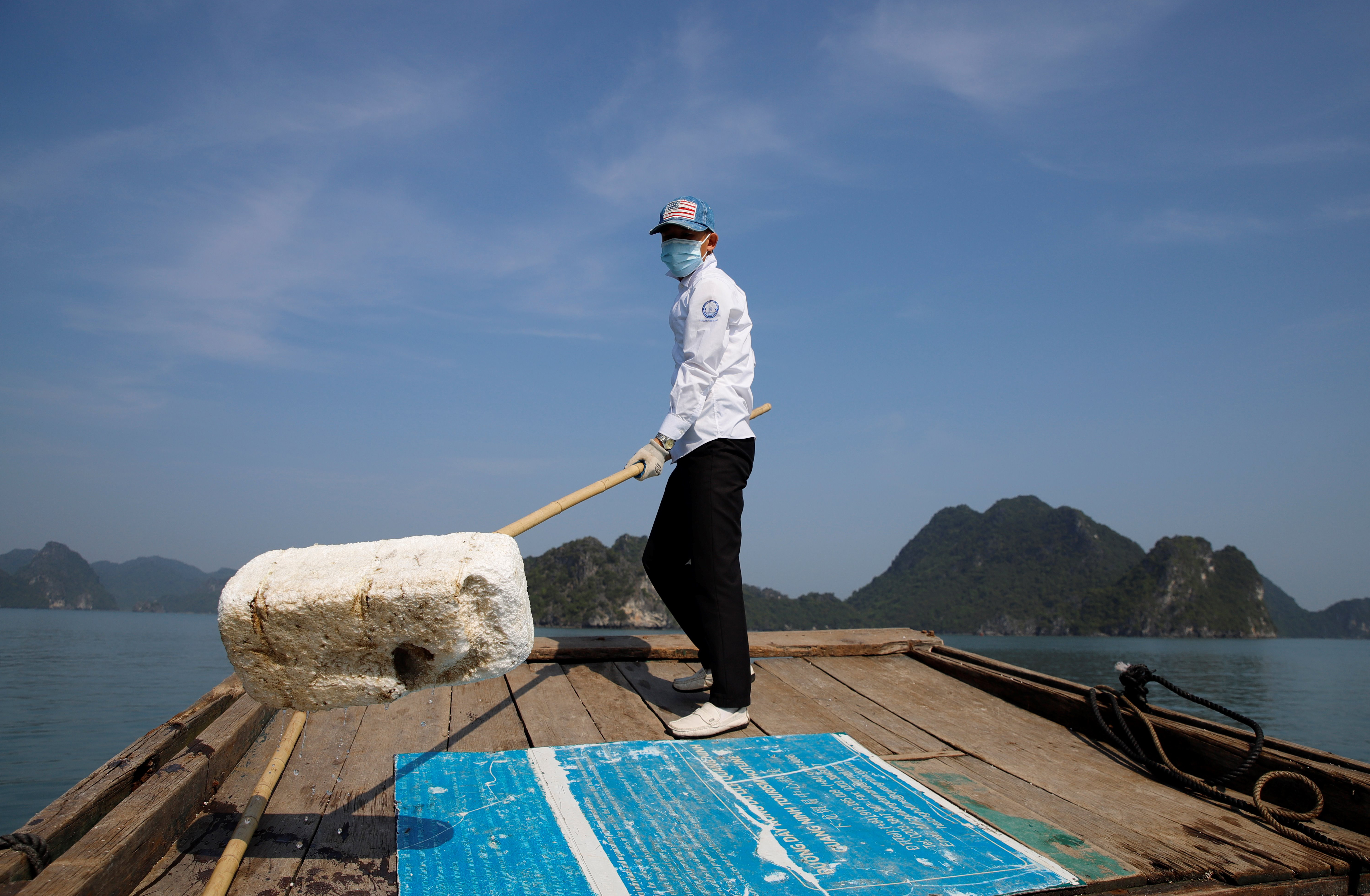 a worker picks up trash from Ha Long Bay in northeast Vietnam.