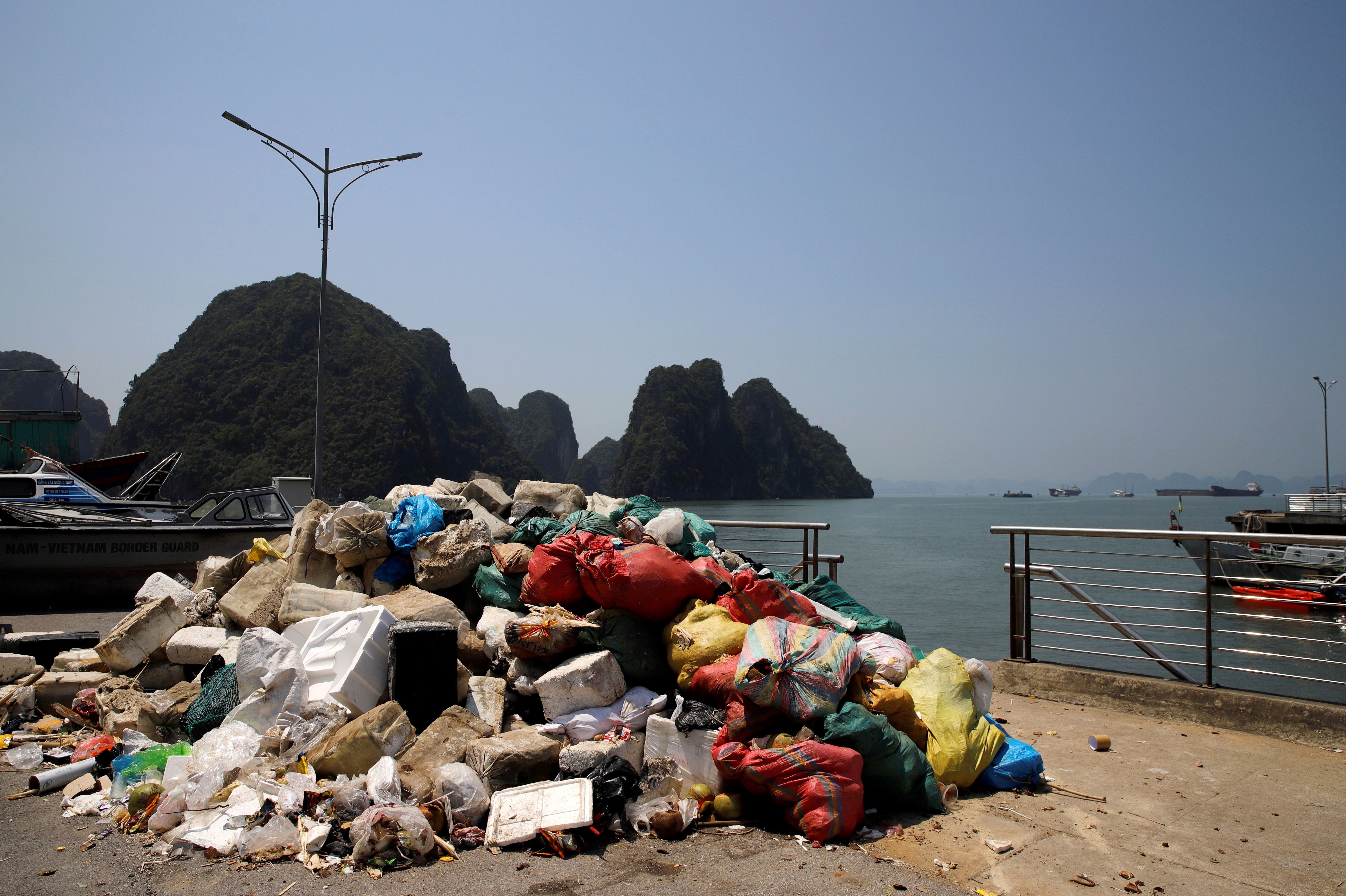 a worker picks up trash from Ha Long Bay in northeast Vietnam.