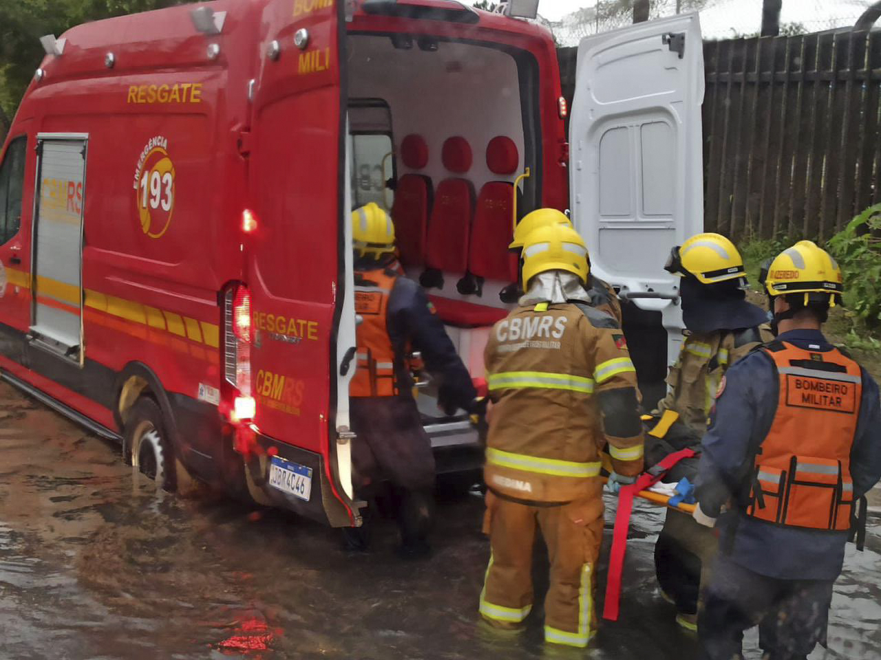 A handout picture released by the Rio Grande do Sul State Government shows firemen moving a person into an ambulance in a flooded street in Porto Alegre