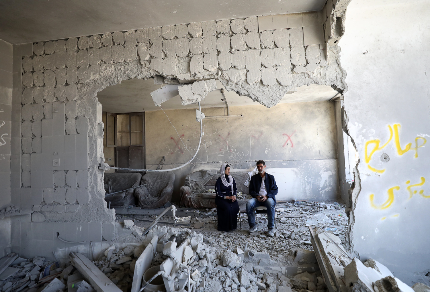 Hani and Tamara al-Jouri amidst the wreckage of their family home, which was destroyed by Israeli soldiers overnight Thursday, in Nablus, West Bank