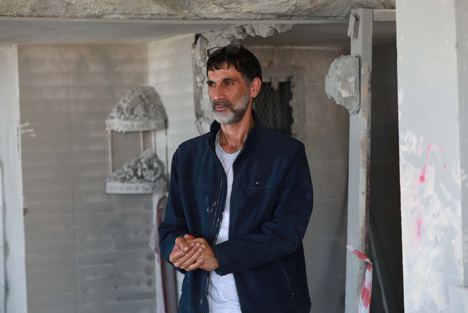 Hani stands stunned in the middle of his destroyed home