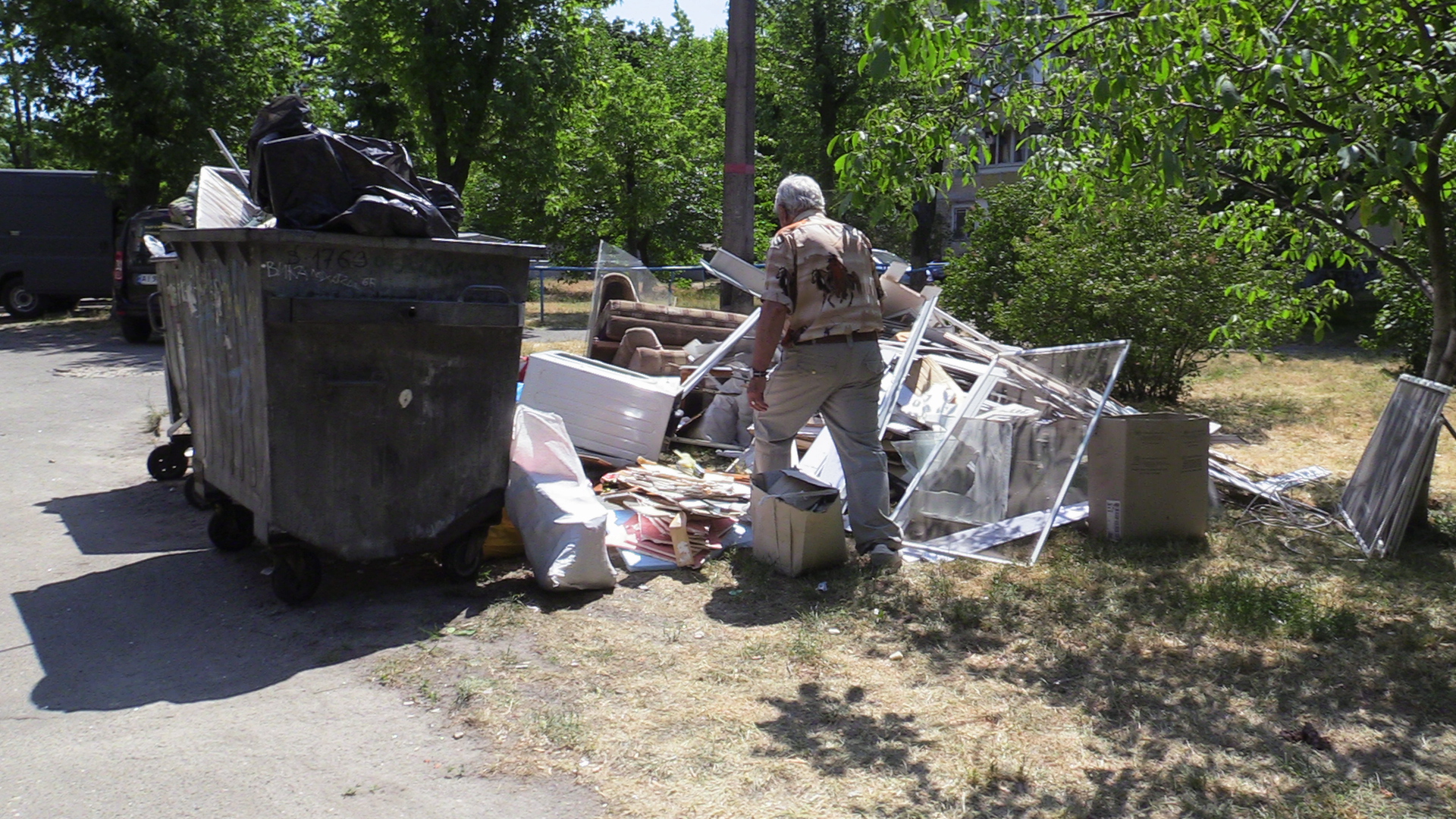 A Ukrainian man piling throws away broken glass and windowpanes after a Russian cruise missile was shot down above his apartment building early -1685630711