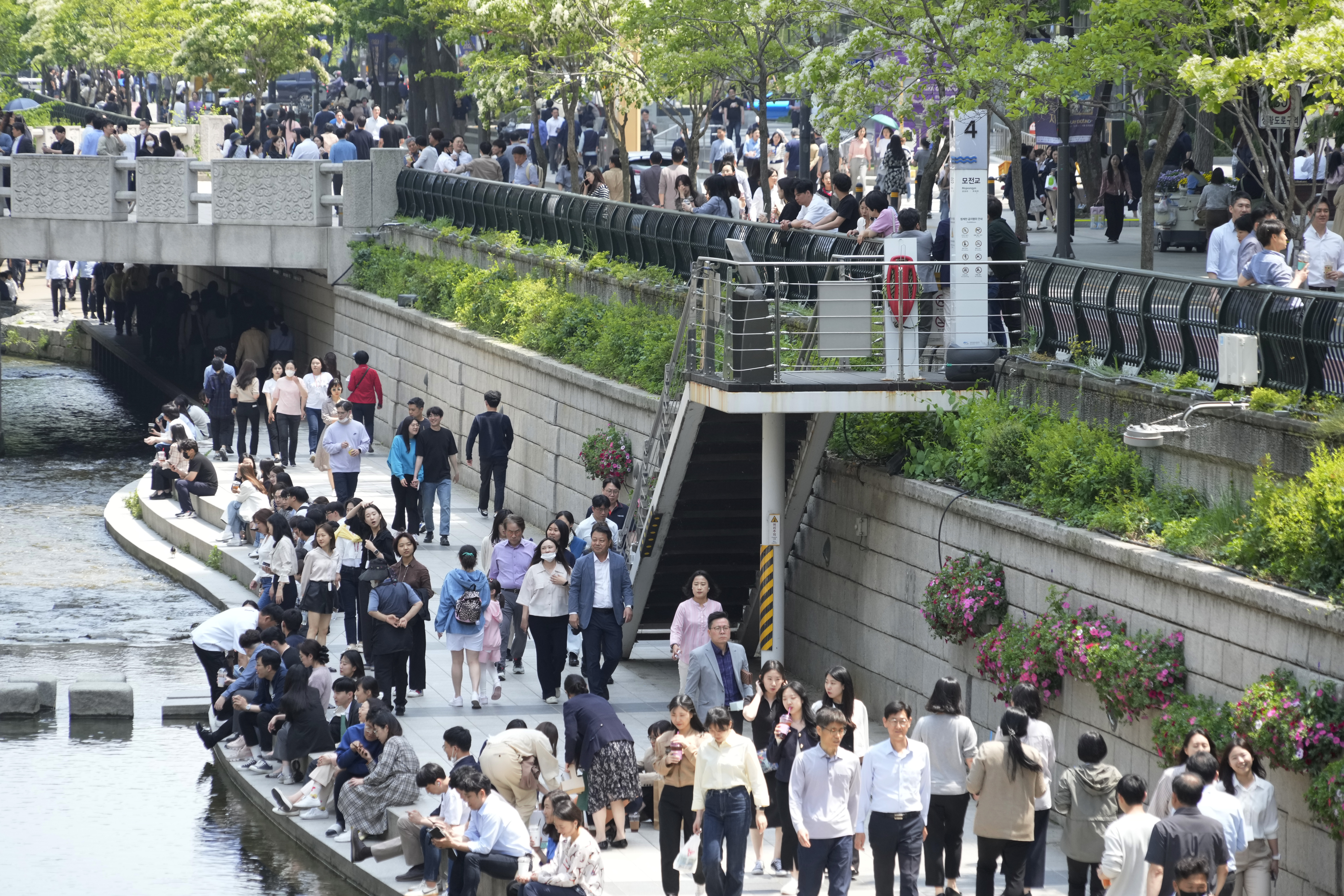 People walk along the public area of the Cheonggye Stream in Seoul, South Korea, Thursday, May 11, 2023.