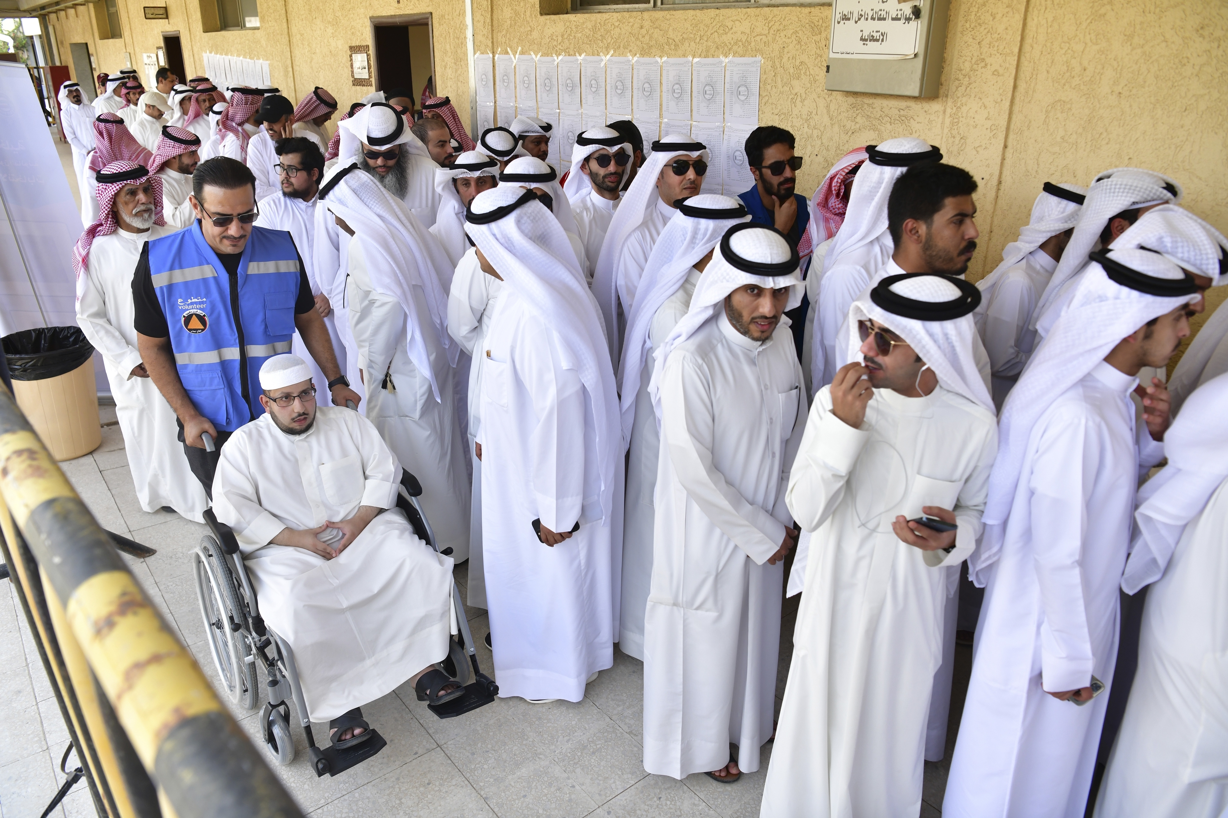 People stand in line to cast their votes in National Assembly elections