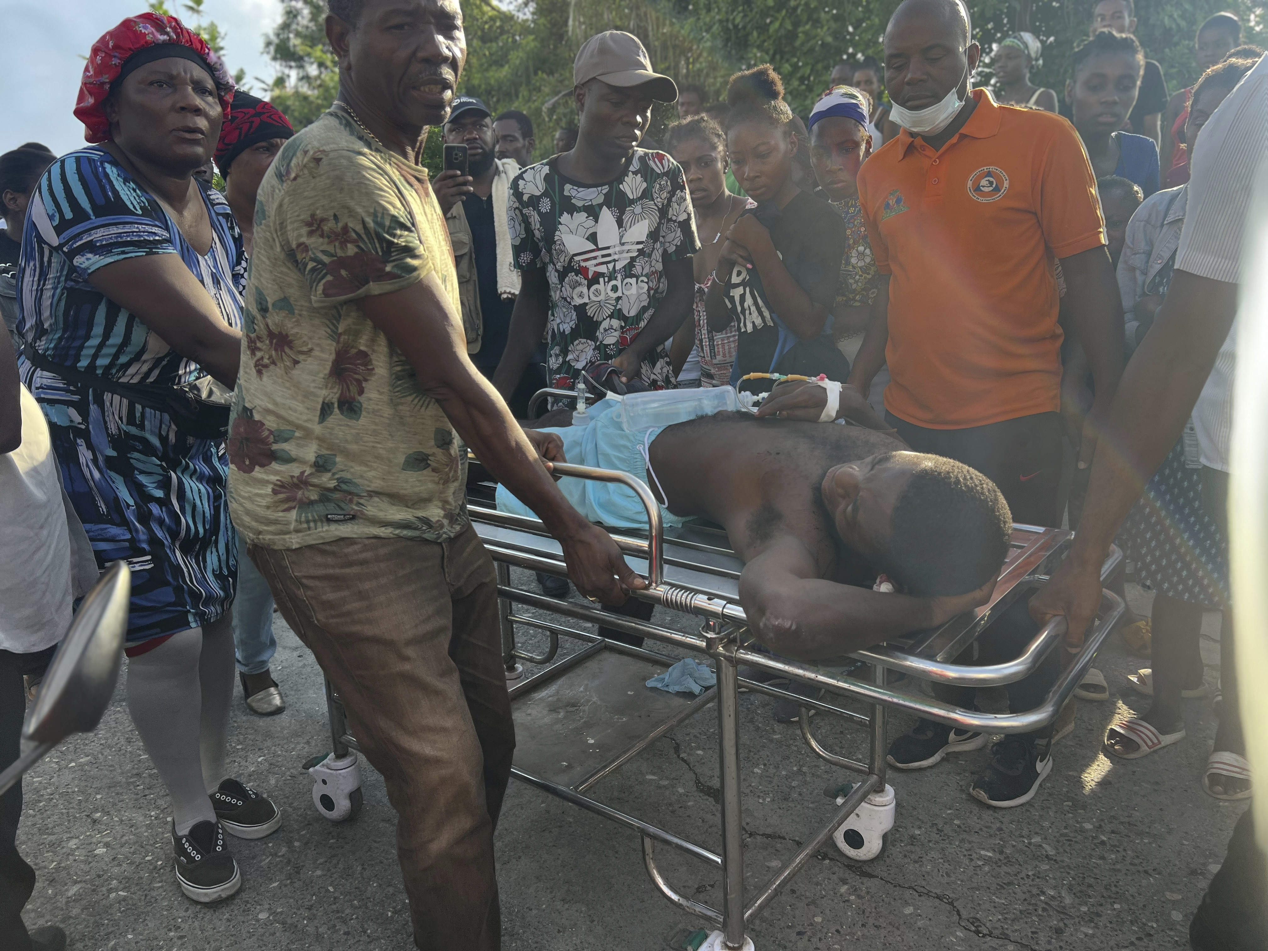 People transport an injured person after rescuing him from a house that collapse