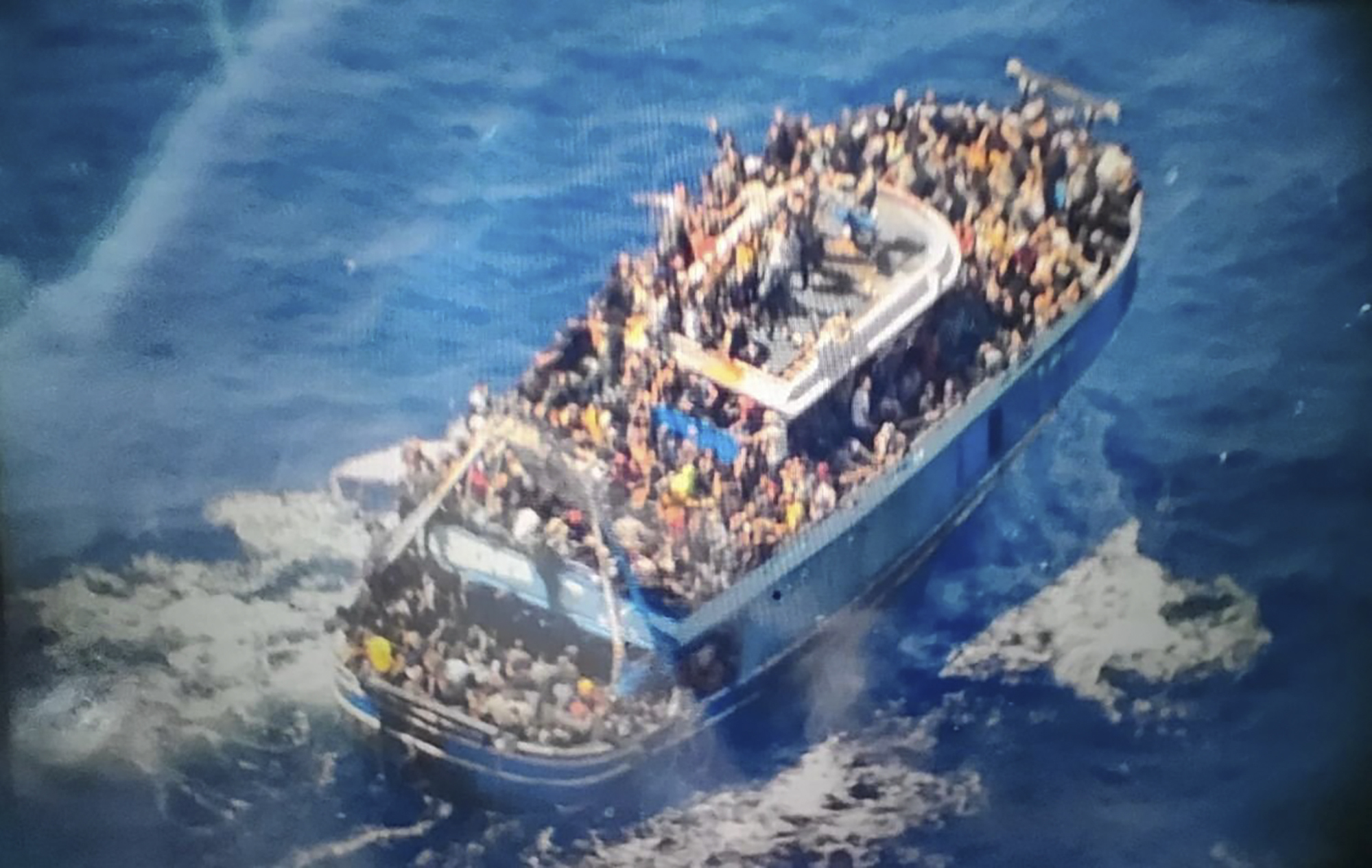 scores of people covering practically every free stretch of deck on a battered fishing boat that later capsized and sank off southern Greece