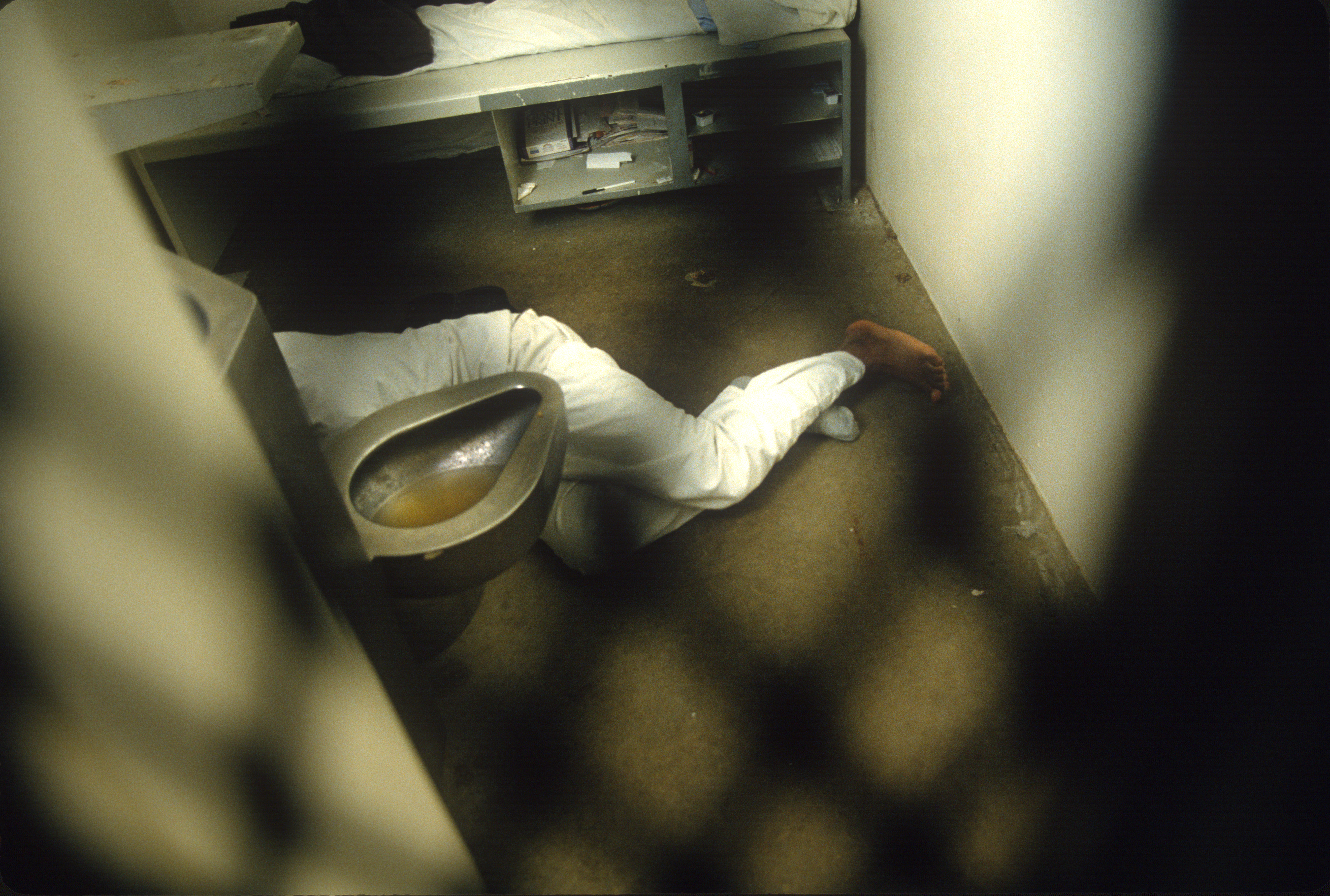 A person lies down in a solitary unit