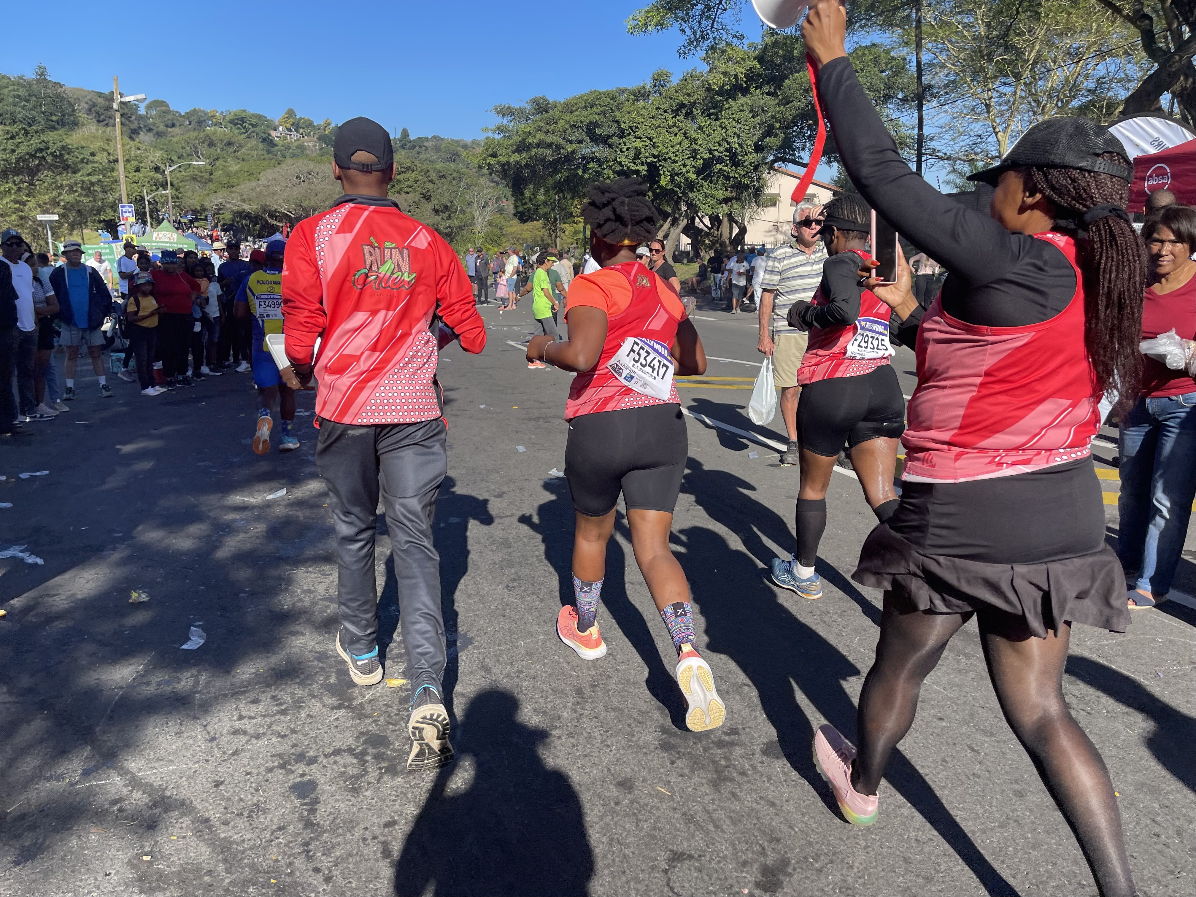 Ashleigh Adams (center) receiving cheers from her teammates from the Run Alex running club in Pinetown, a suburb of Durban, South Africa, 70 kilometers into the 2023 Comrades ultra-marathon.