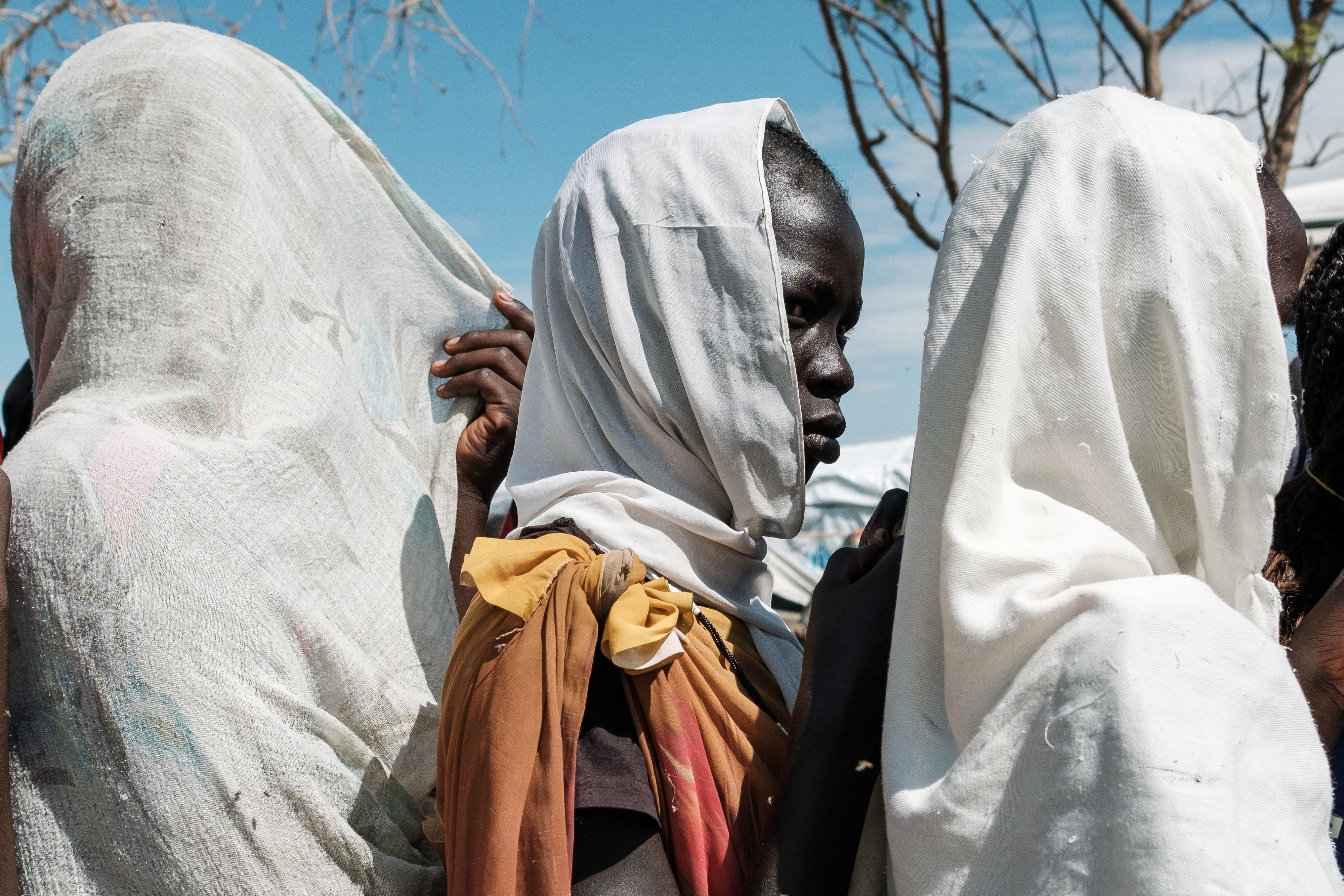 Women wait in line for feminine hygiene products distributed by aid agencies at the Renk transit centre