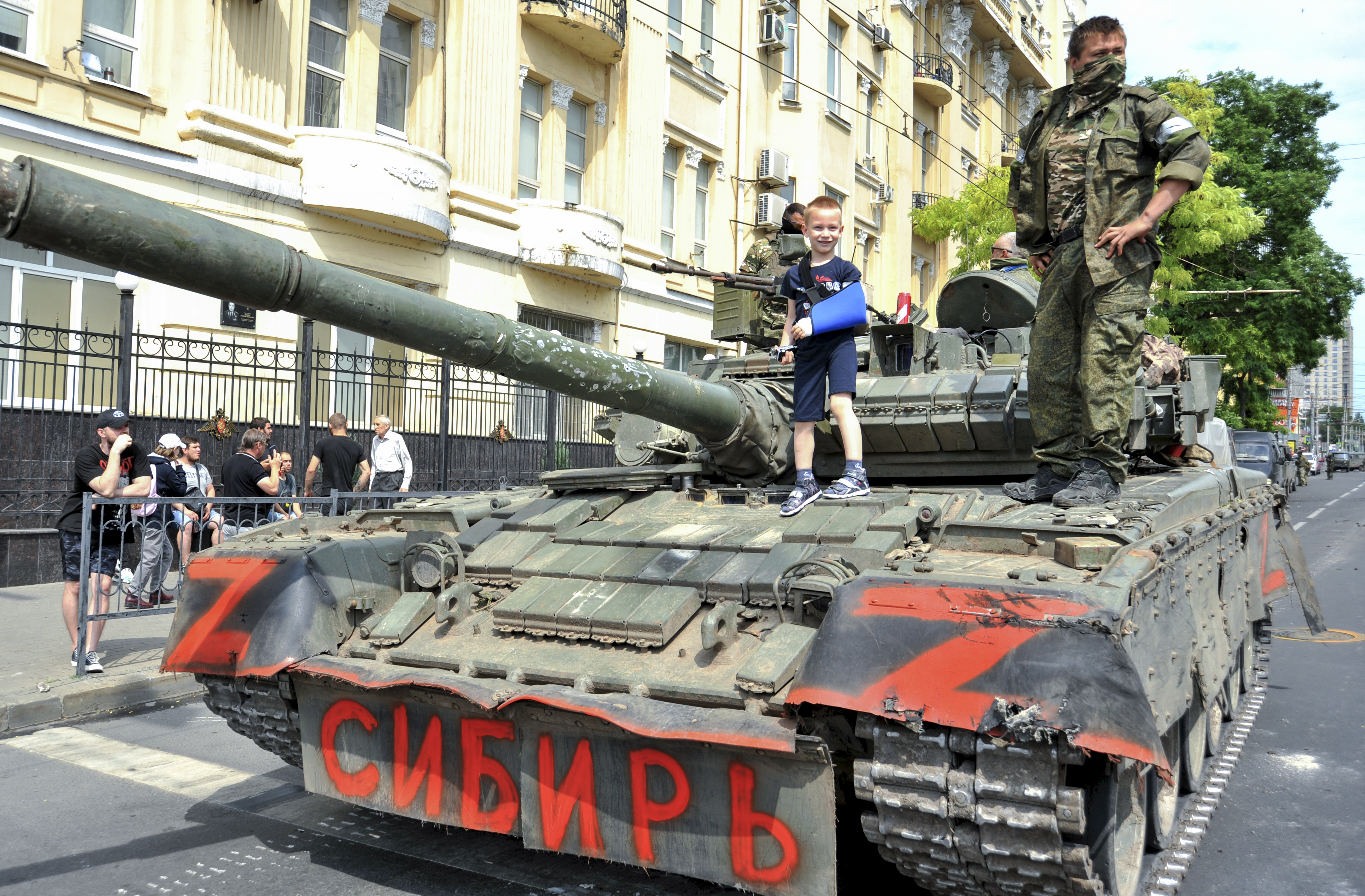 epa10709141 A child poses for a photo on a tank reading 'Siberia' as servicemen from private military company (PMC) Wagner Group block a street in downtown Rostov-on-Don, southern Russia, 24 June 2023. Security and armoured vehicles were deployed after Wagner Group's chief Yevgeny Prigozhin said in a video that his troops had occupied the building of the headquarters of the Southern Military District, demanding a meeting with Russias defense chiefs. EPA-EFE/ARKADY BUDNITSKY