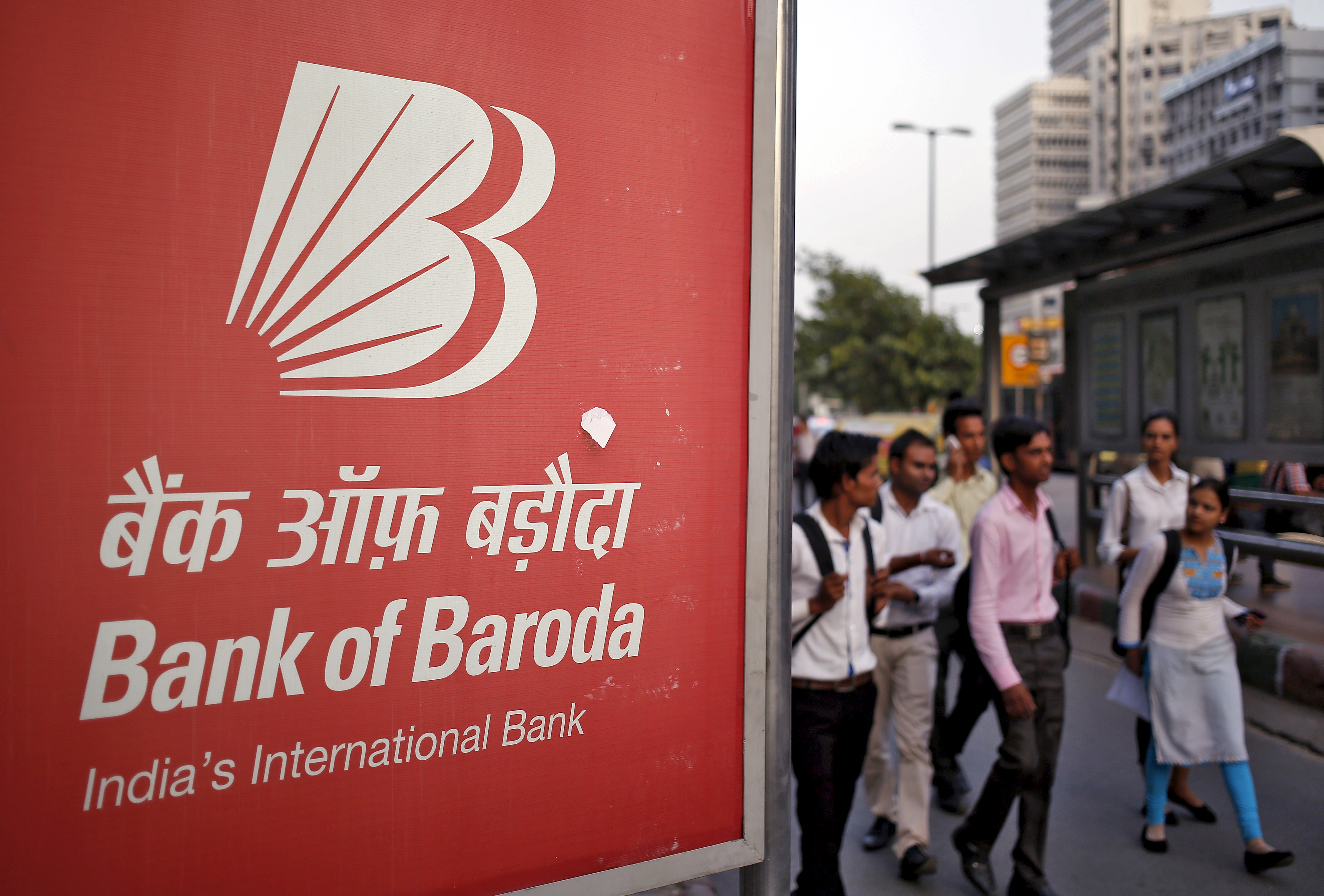 Commuters walk past an advertisement of Bank of Baroda, India's second-biggest state-owned bank, at a busy street in New Delhi, India