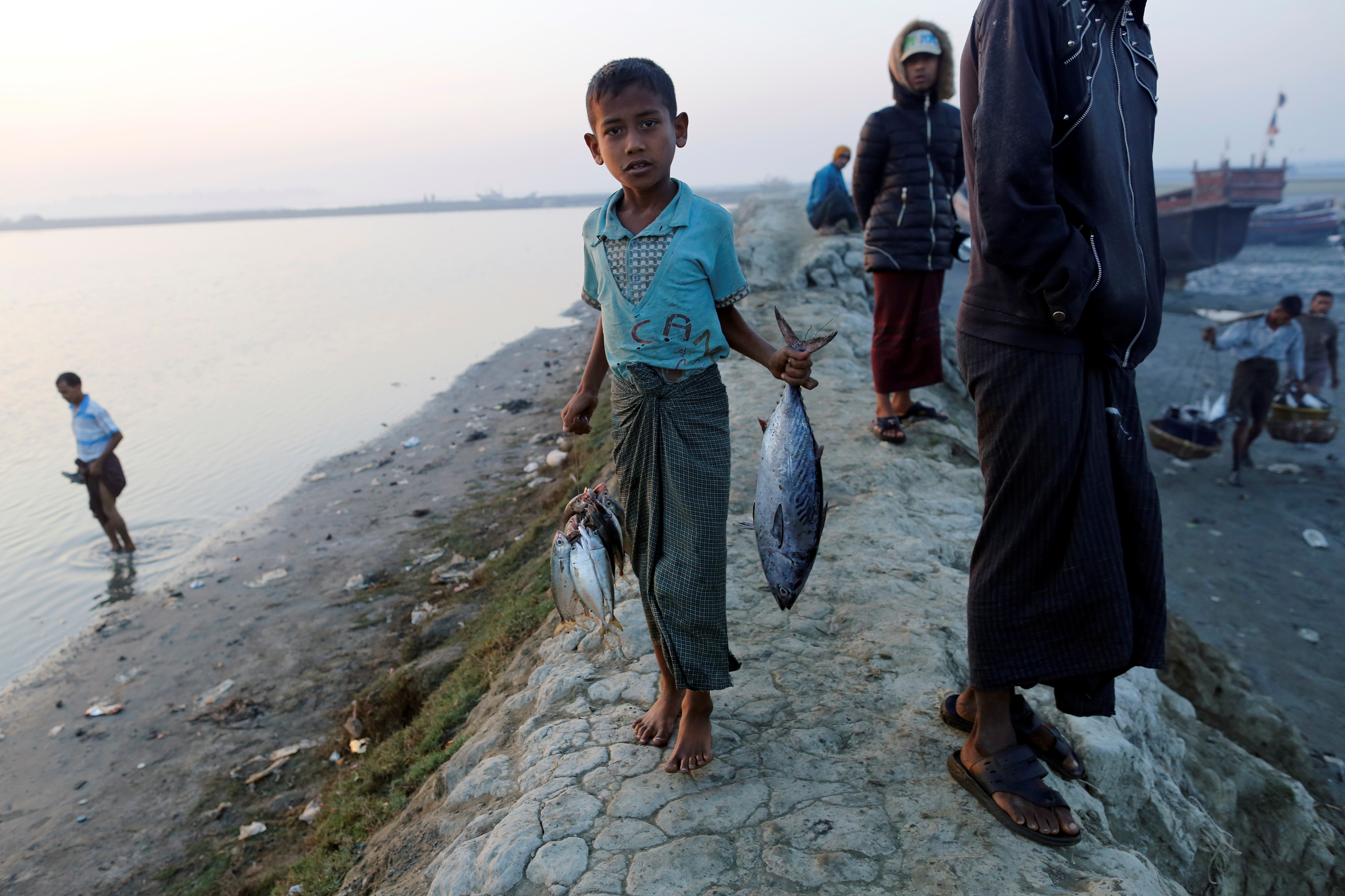 A Rohingya boy carries fishes at the beach in Sittwe in the state of Rakhine, Myanmar March 2, 2017. Picture taken March 2, 2017. REUTERS/Soe Zeya Tun