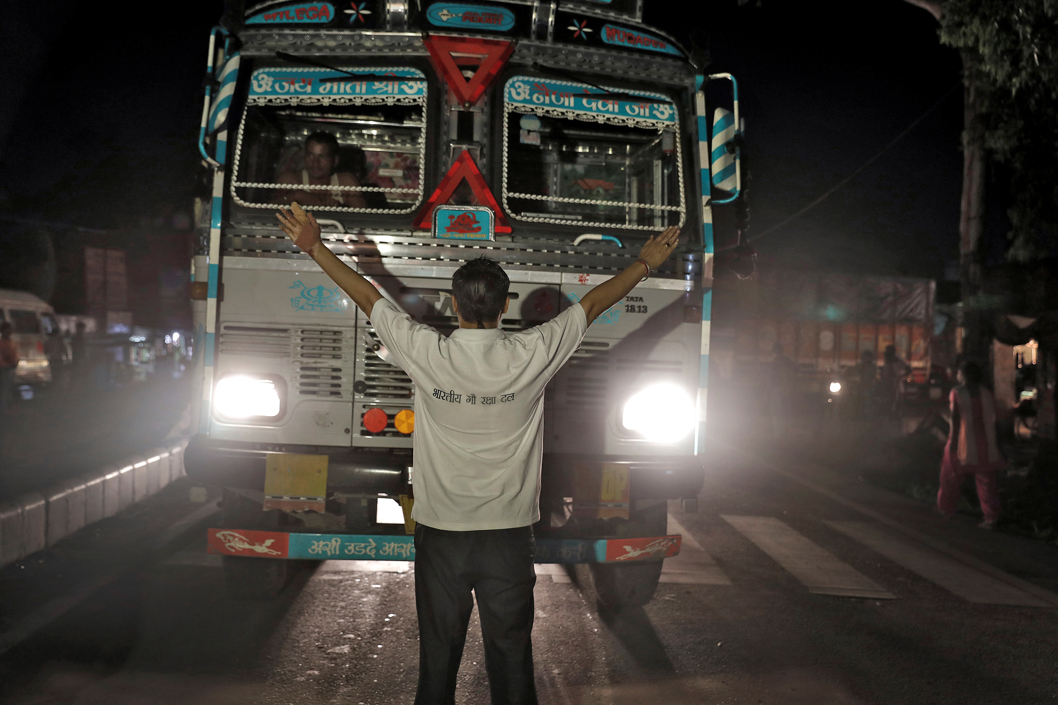 a cow vigilante stops a truck at a road block near Chandigarh, India
