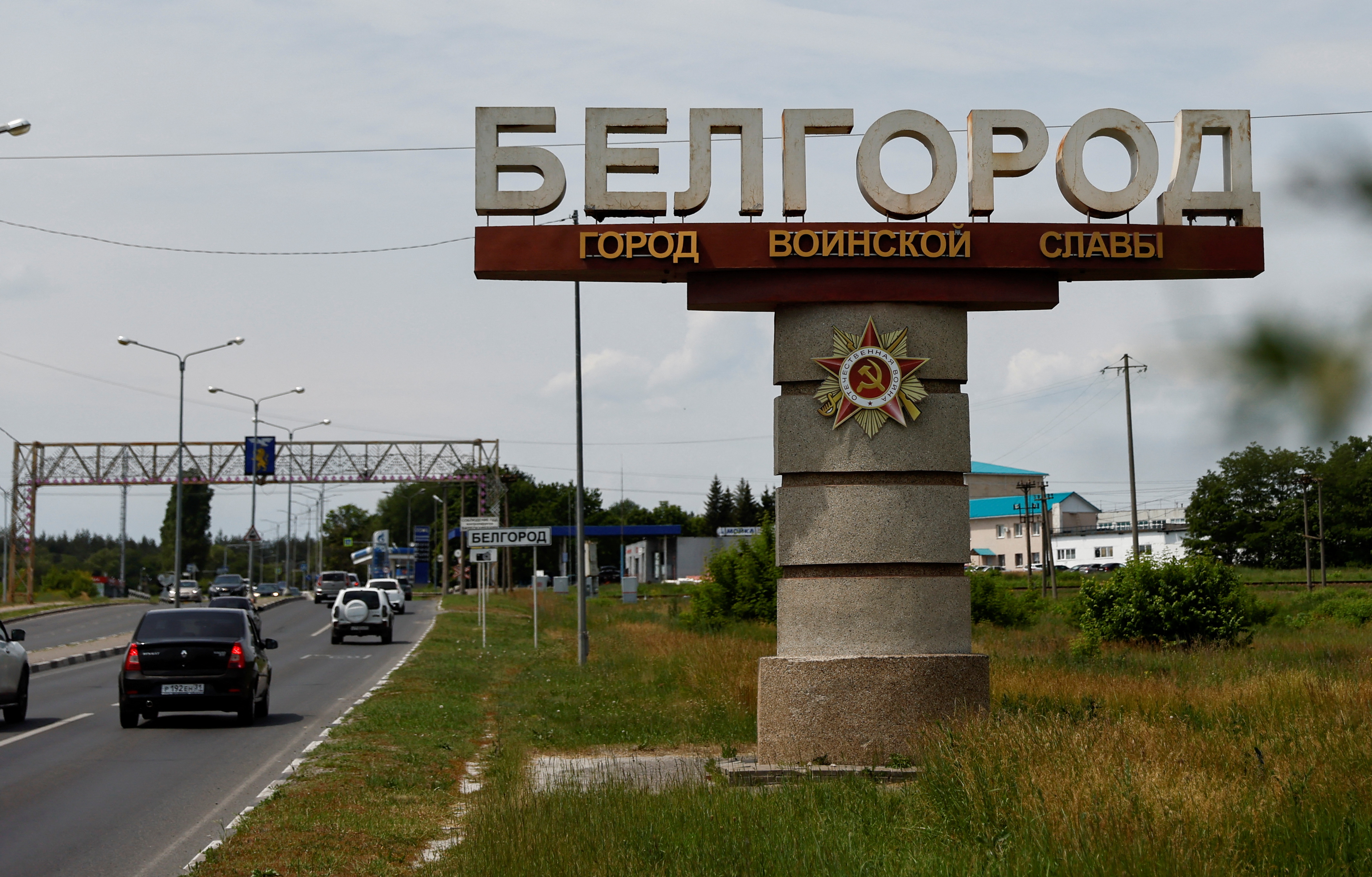 Cars drive past a stele displaying the city name in Belgorod