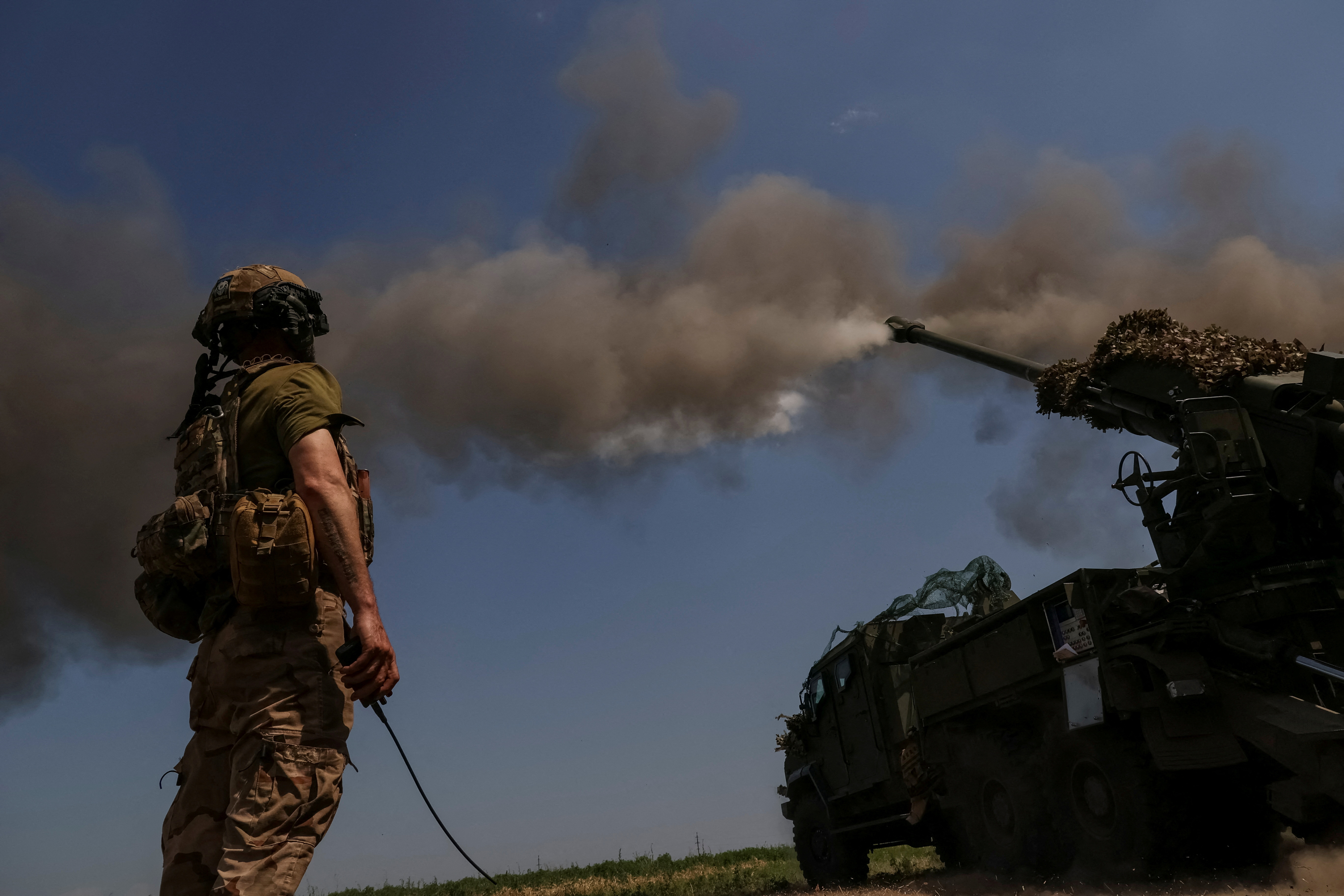 A Ukrainian soldier firesa howitzer towards Russian lines