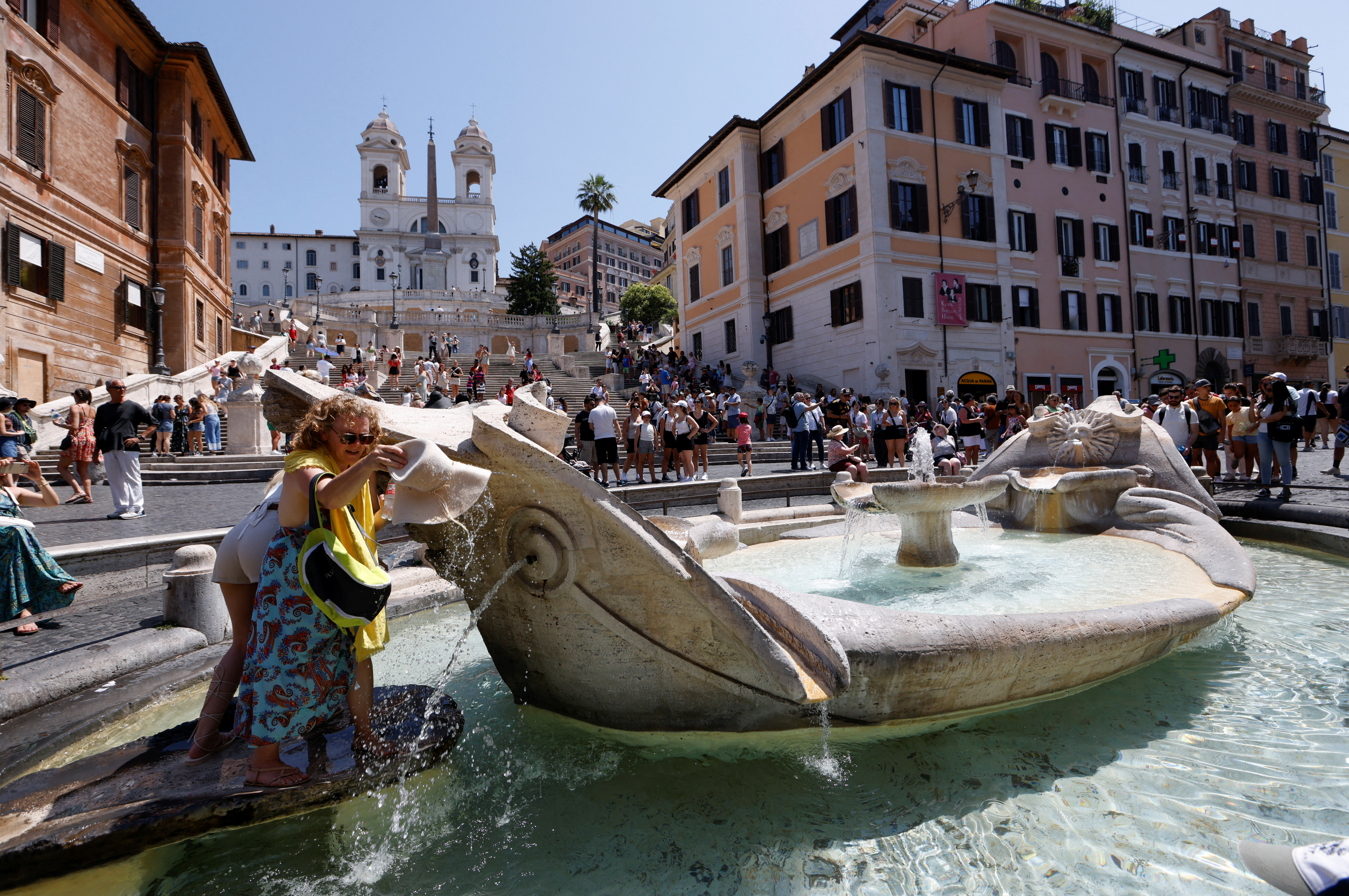 A woman cools off at the Barcaccia fountain near the Spanish Steps during a heatwave across Italy