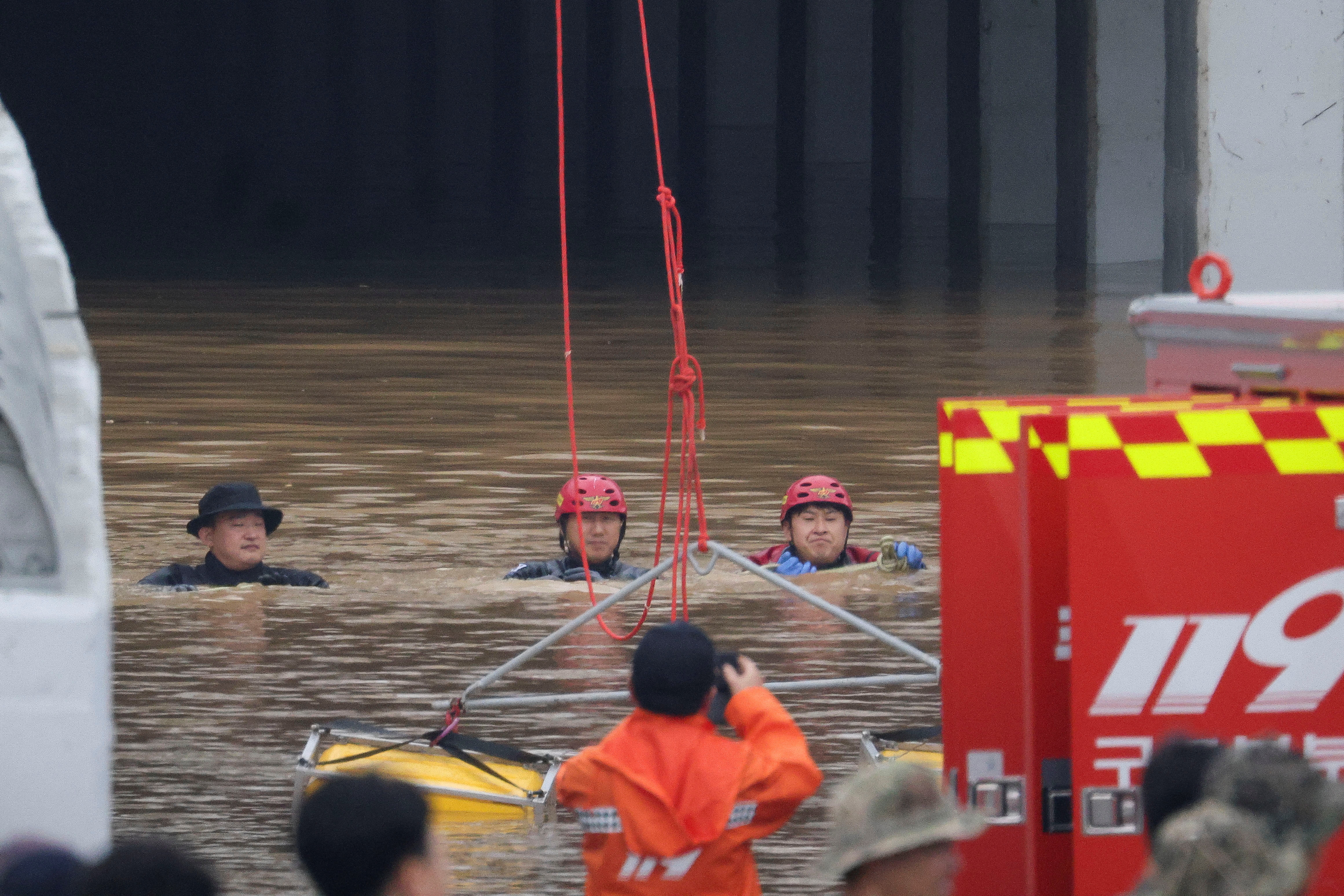 Rescue workers take part in a search and rescue operation near a submerged underpass