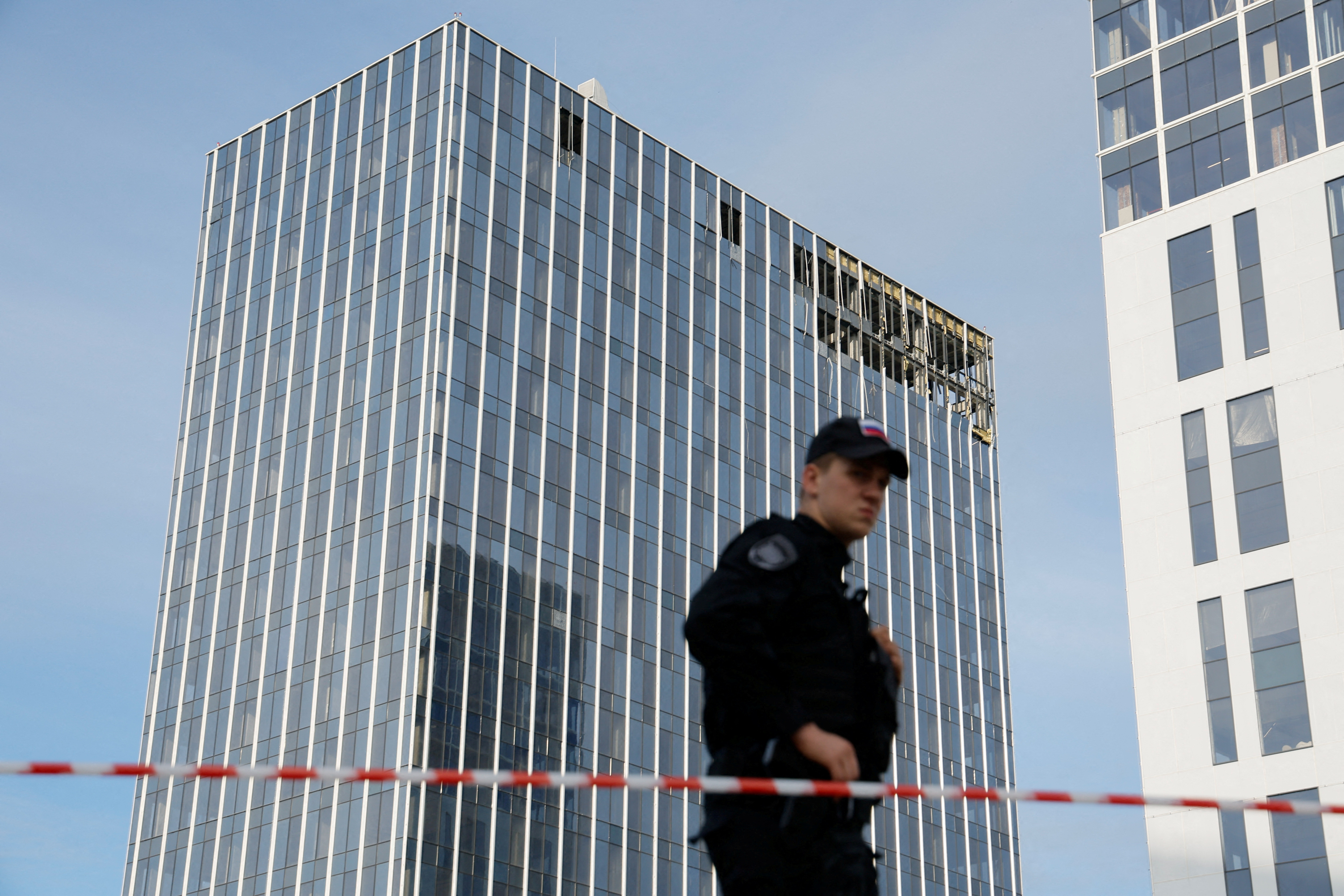 A member of the security services stands guard next to the site of a damaged building following a reported drone attack in Moscow, Russia, July 24, 2023
