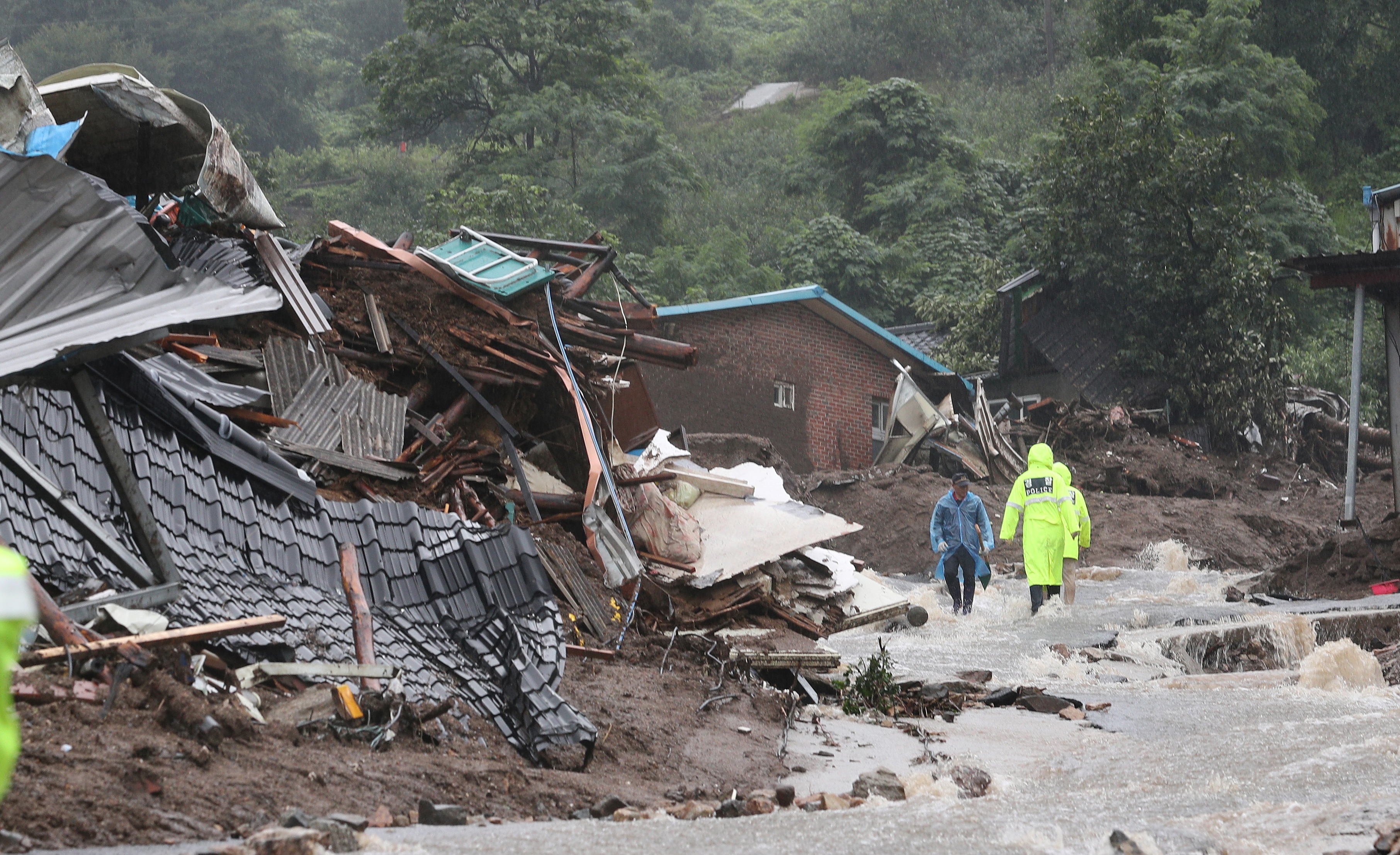 South Korean emergency workers search for survivors after a landslide hit a small village in Yecheon on July 15, 2023. - Seven people have been killed and three were missing as heavy rains flooded South Korea, officials said on July 15, with thousands told to evacuate their homes due to an overflowing dam. (Photo by - / YONHAP / AFP) / - South Korea OUT / NO USE AFTER AUGUST 14, 2023 15:00:00 GMT - - SOUTH KOREA OUT / REPUBLIC OF KOREA OUT NO ARCHIVES RESTRICTED TO SUBSCRIPTION USE - REPUBLIC OF KOREA OUT NO ARCHIVES RESTRICTED TO SUBSCRIPTION USE