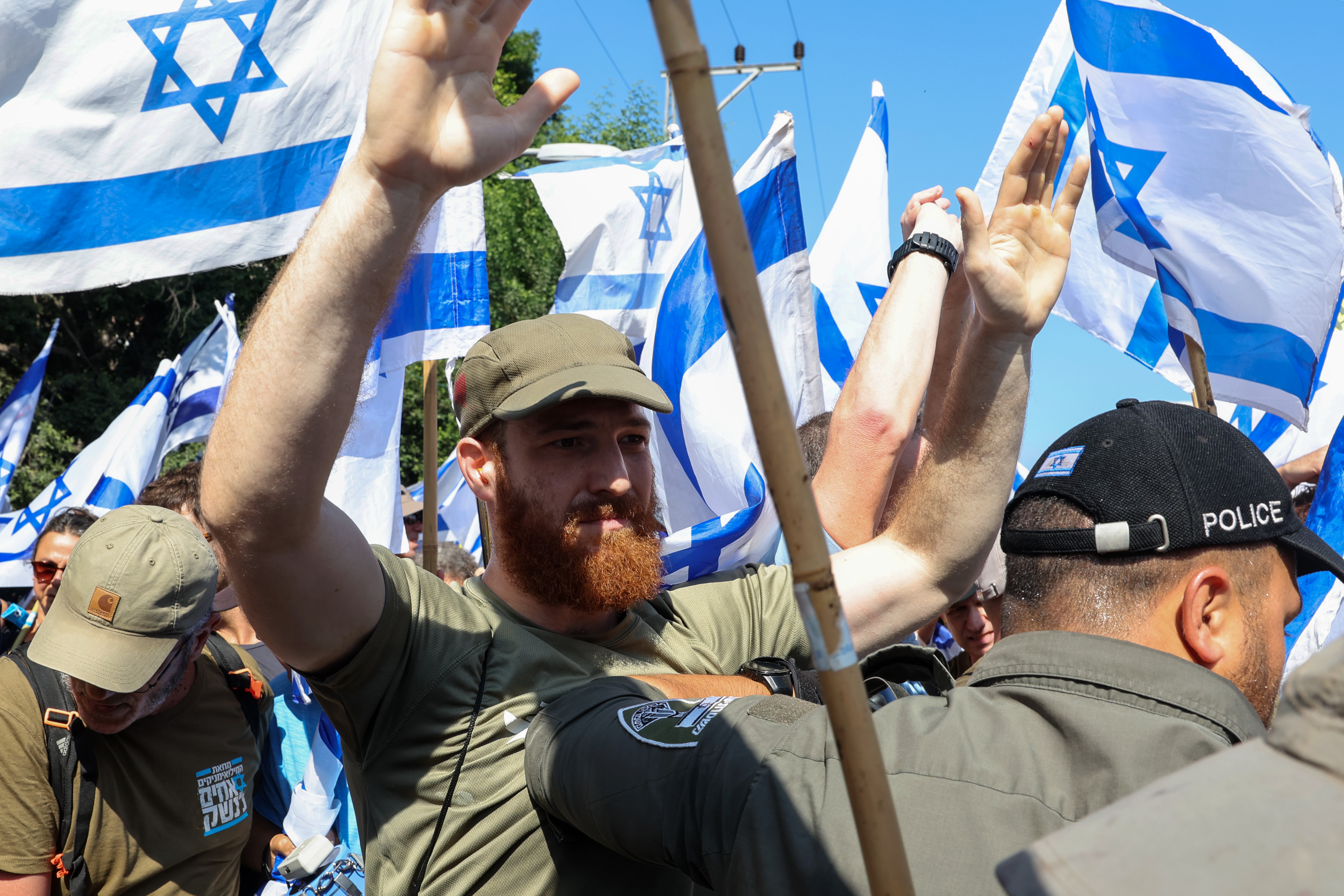 Members of Israeli security forces disperse demonstrators staging a 'day of resistance' to protest the government's judicial overhaul bill, in Tel Aviv on July 18, 2023. - The proposals have divided the nation and triggered one of the biggest protest movements in Israel's history since being unveiled in January by the hard-right government of Prime Minister Benjamin Netanyahu. (Photo by JACK GUEZ / AFP)