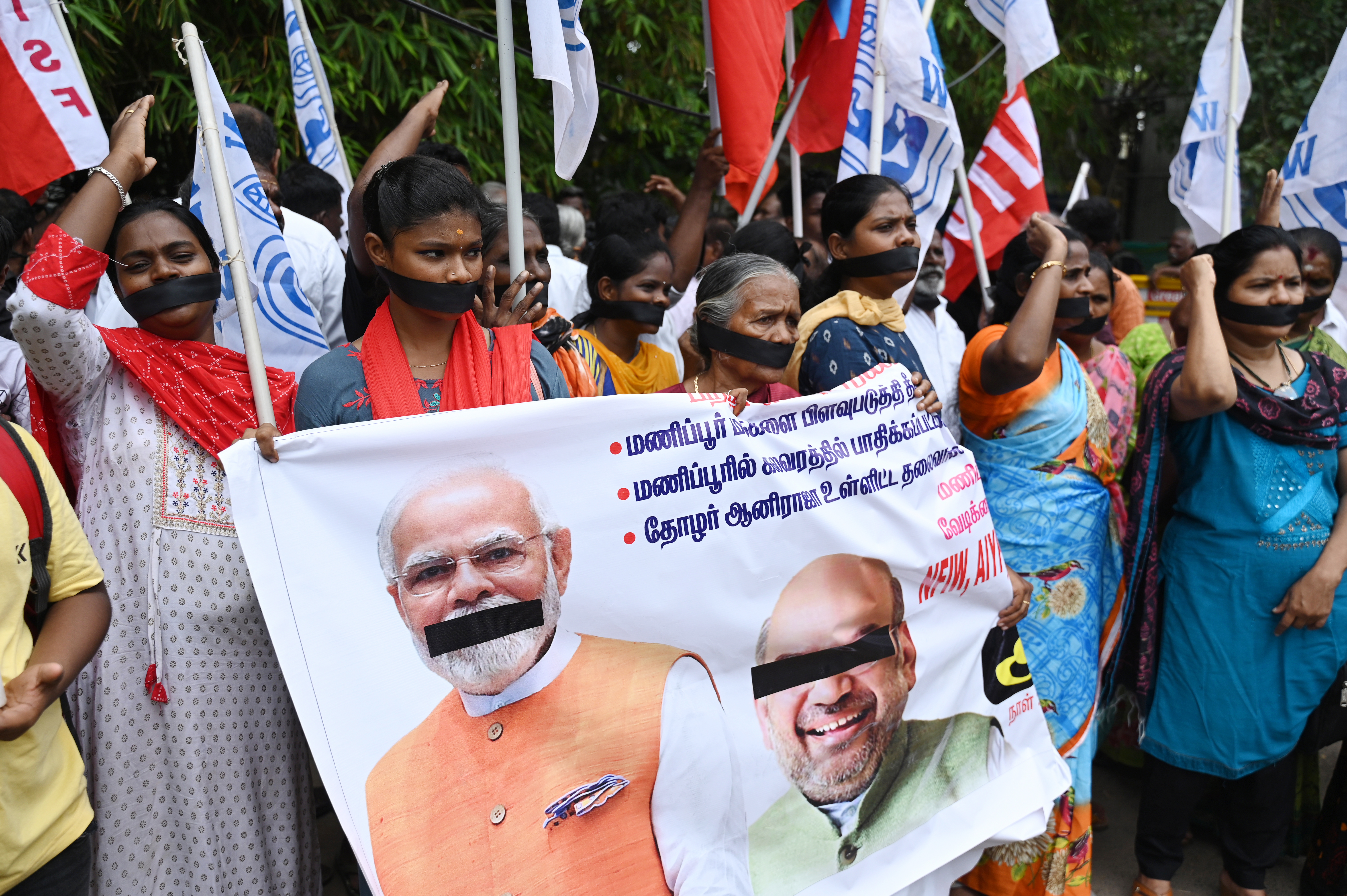 Demonstrators with black clothes covering their mouths shout slogans during a protest over sexual violence against women in the ongoing ethnic violence in India's north-eastern state of Manipur, in Chennai on July 22, 2023. (Photo by R.Satish BABU / AFP)