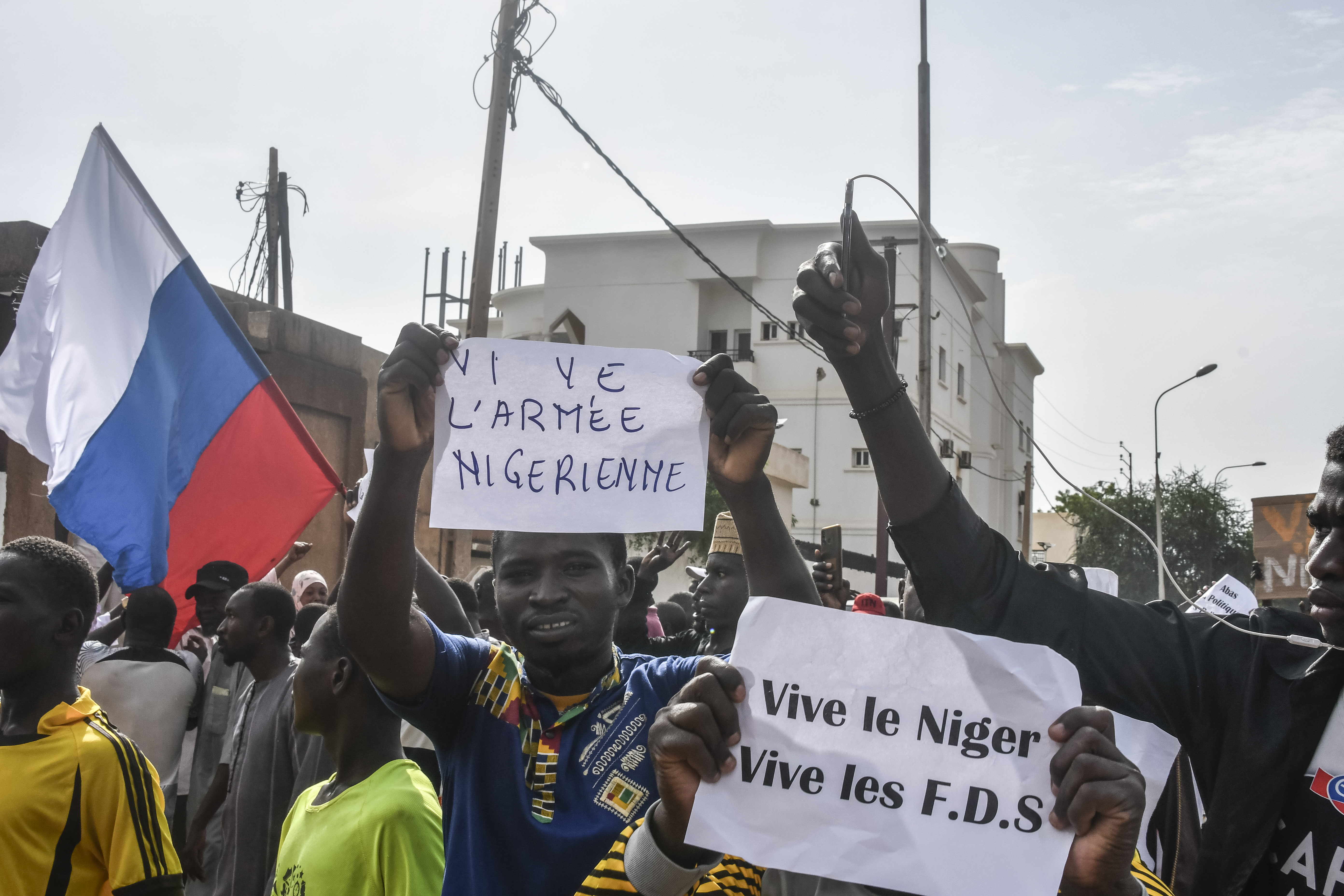 Supporters wave Russian flags and placards as they rally in support of Niger's junta in Niamey.