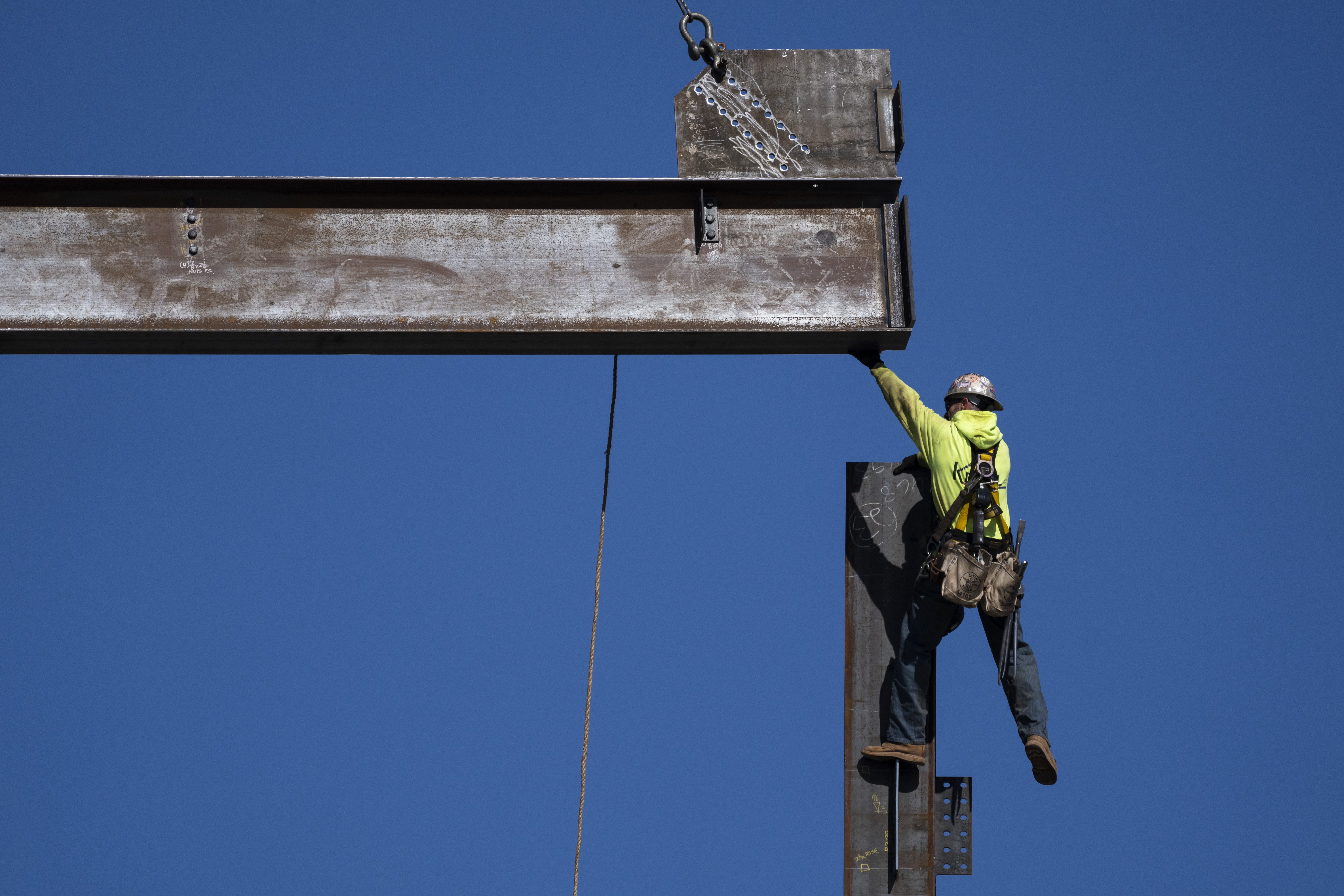 An ironworker guides a beam during construction of a municipal building in Norristown, Pennsylvania, US