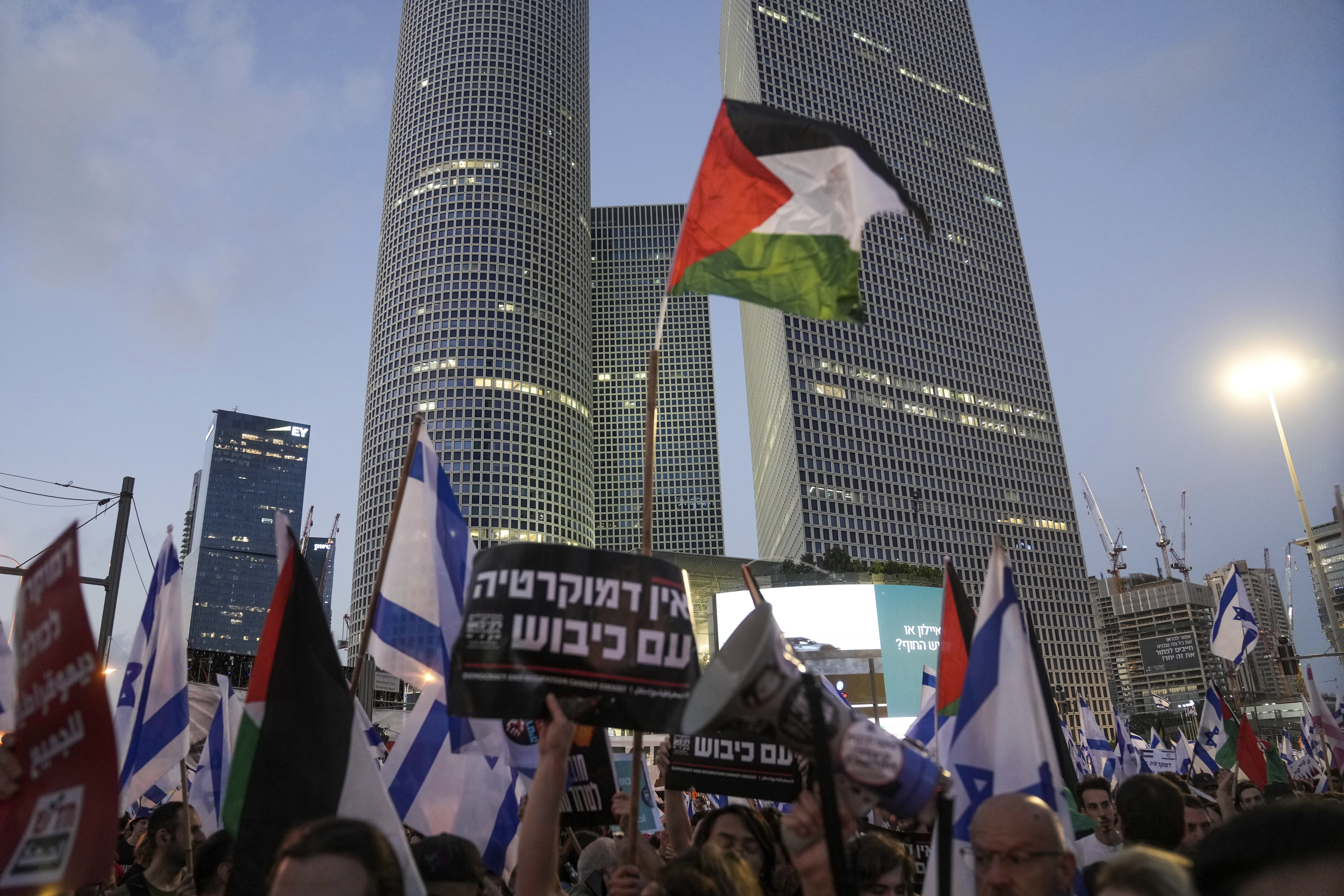 Demonstrators wave the Israeli and Palestinian flags