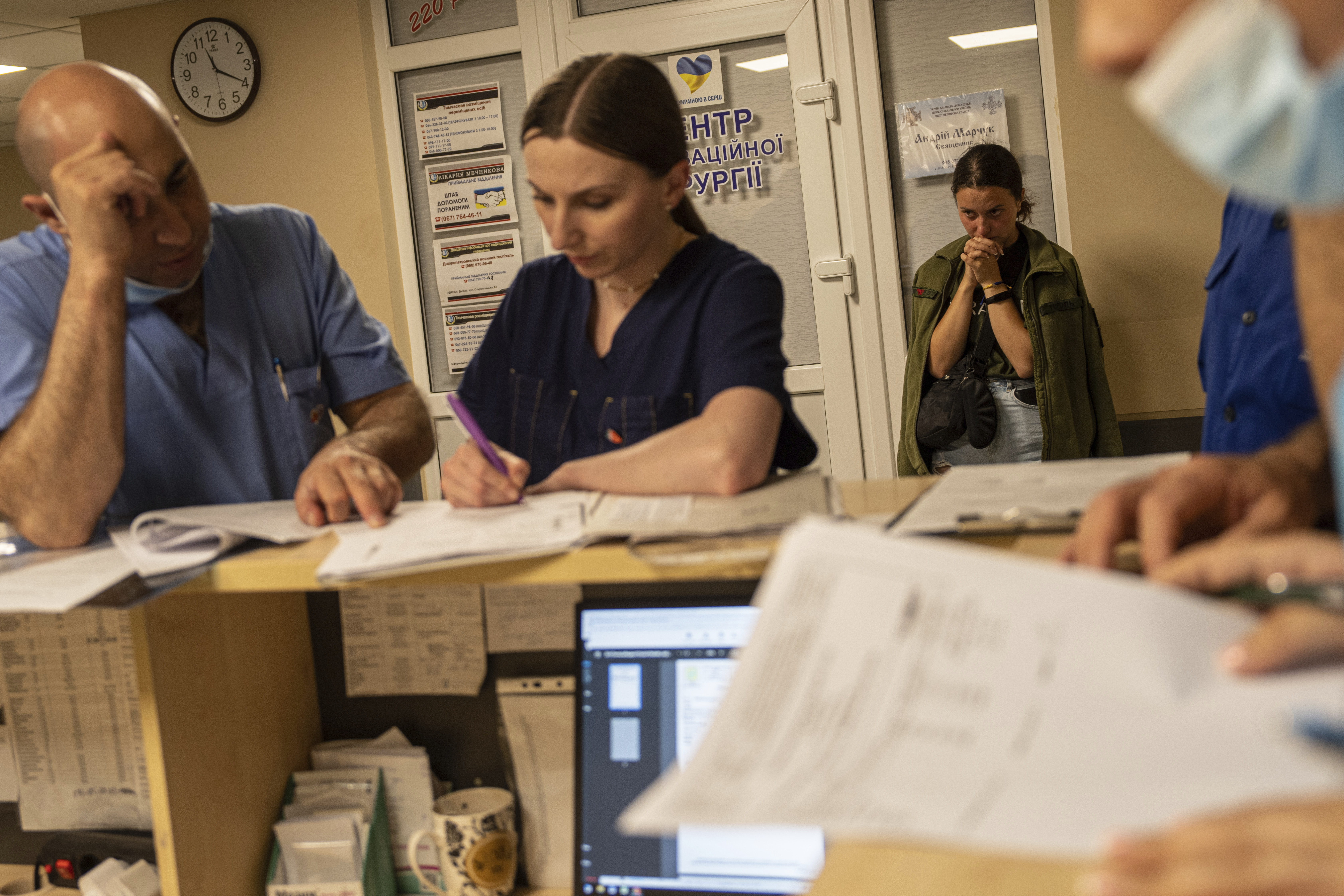 A girlfriend of a Ukrainian soldier prays in the corridor