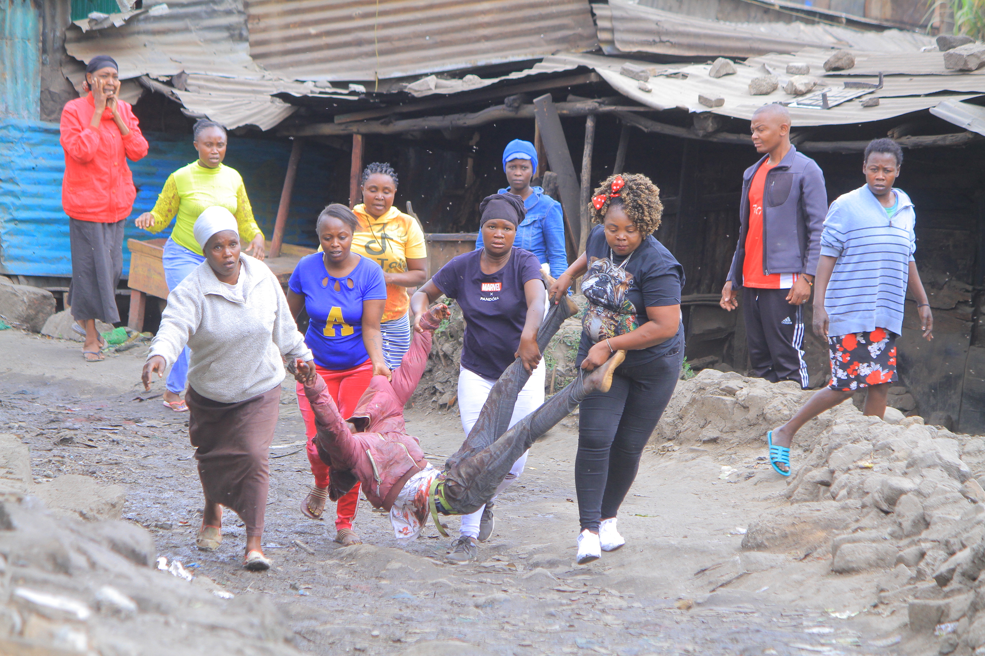 A group of women carrying a man injured during protests to a nearby hospital in Mathare, Nairobi, Kenya
