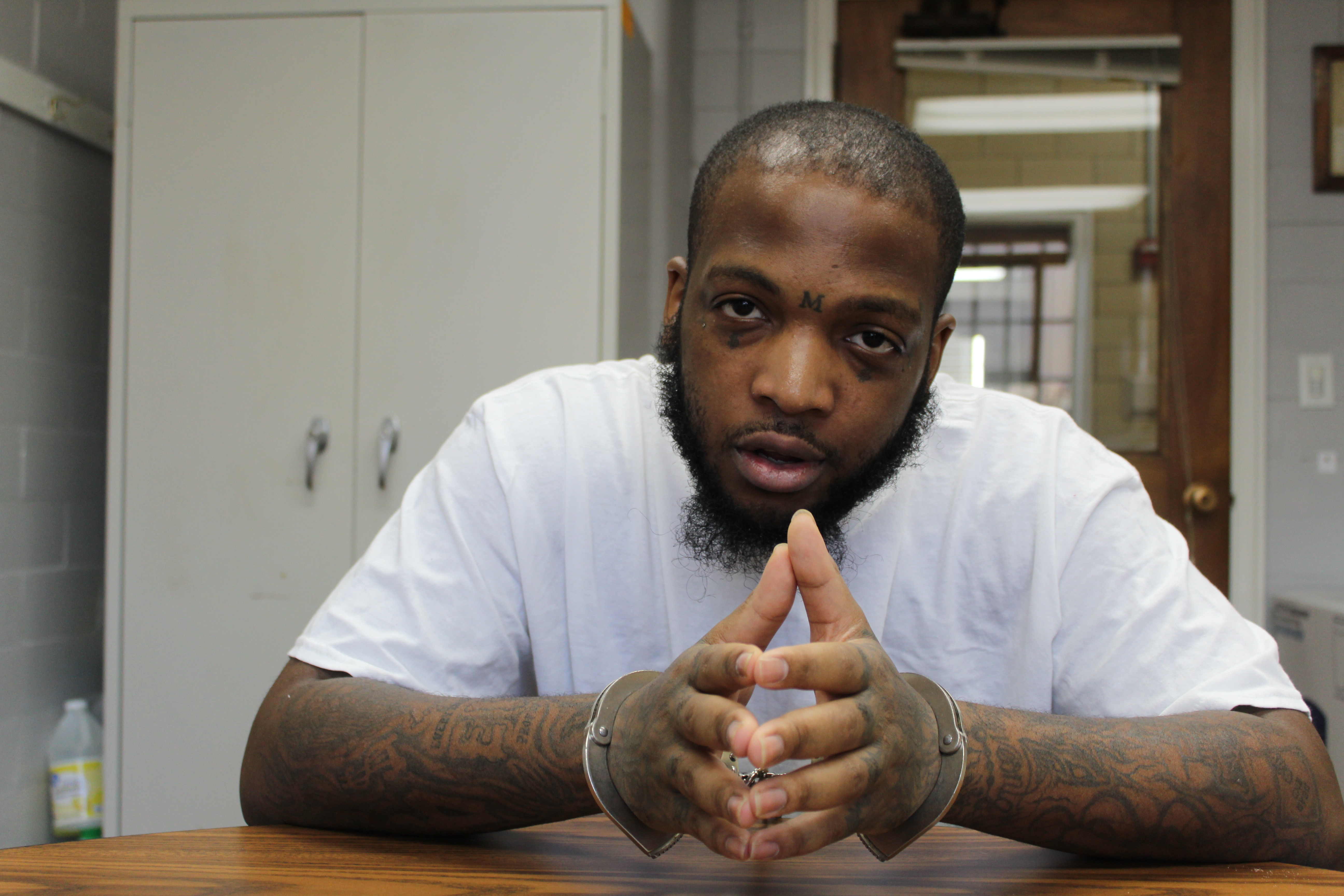 A photo of Marcus (Maleek) Howard in handcuffs.